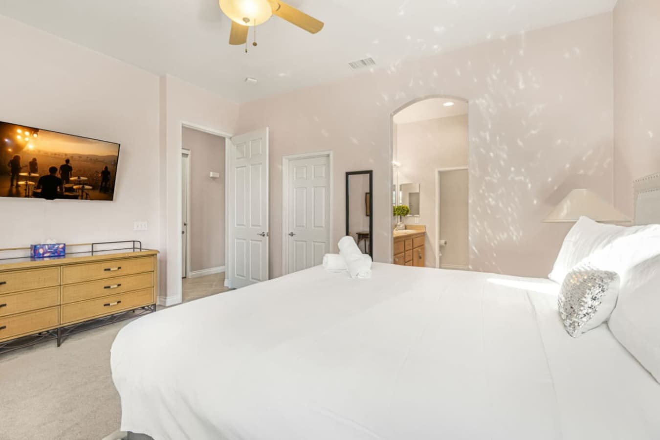 Calm bedroom retreat w/ crisp bedding, warm wood accents, and plenty of space to fully relax.