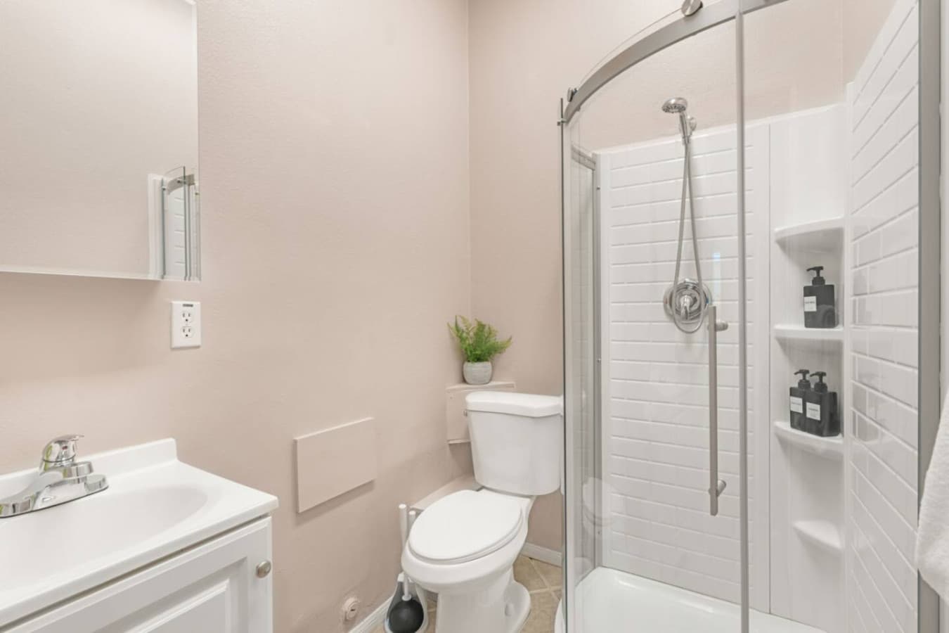 Clean bathroom w/ glass-enclosed shower, bright finishes, and a simple setup for easy daily routines.