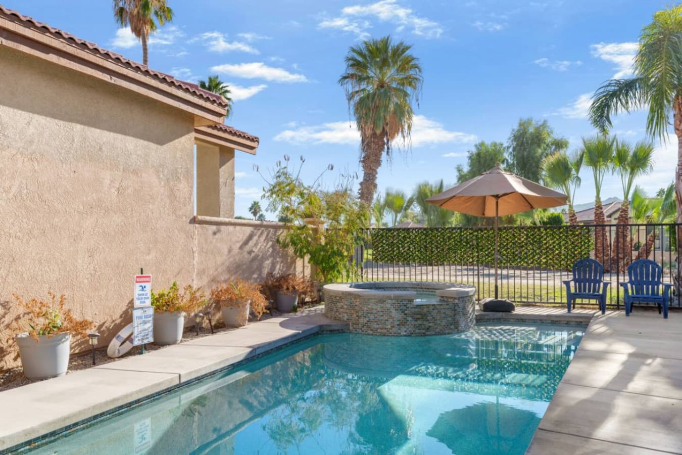 Private backyard pool w/ lounge seating and tall palms creating a relaxed desert escape.