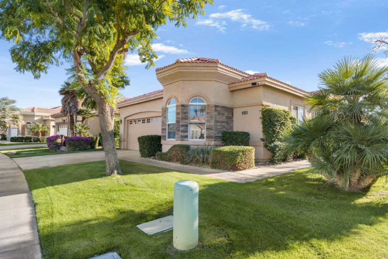 Exterior view highlighting the home’s warm tones, landscaping, and inviting curb appeal.