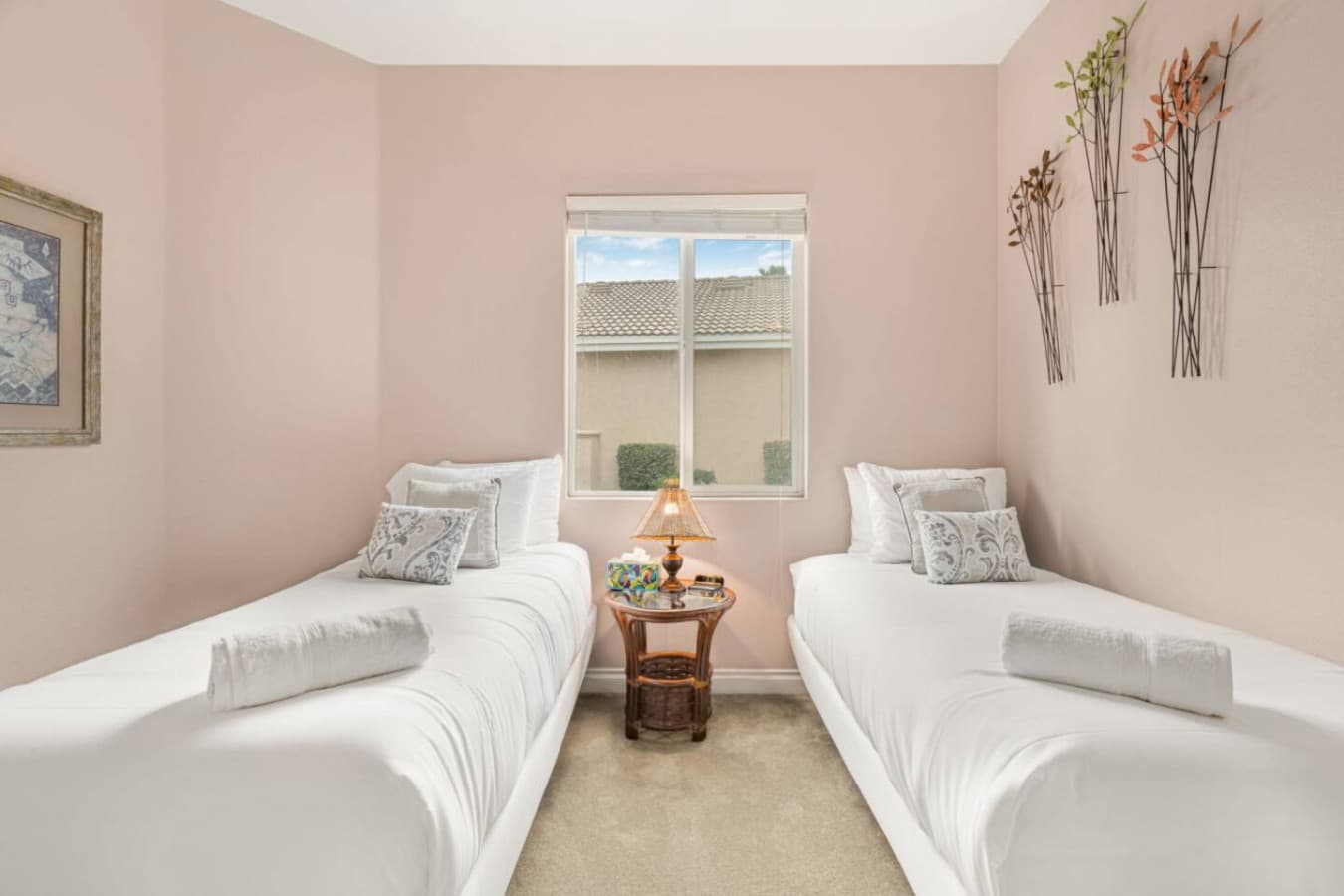 Alternate angle of the twin bedroom showing bright windows and a comfortable, uncluttered layout.