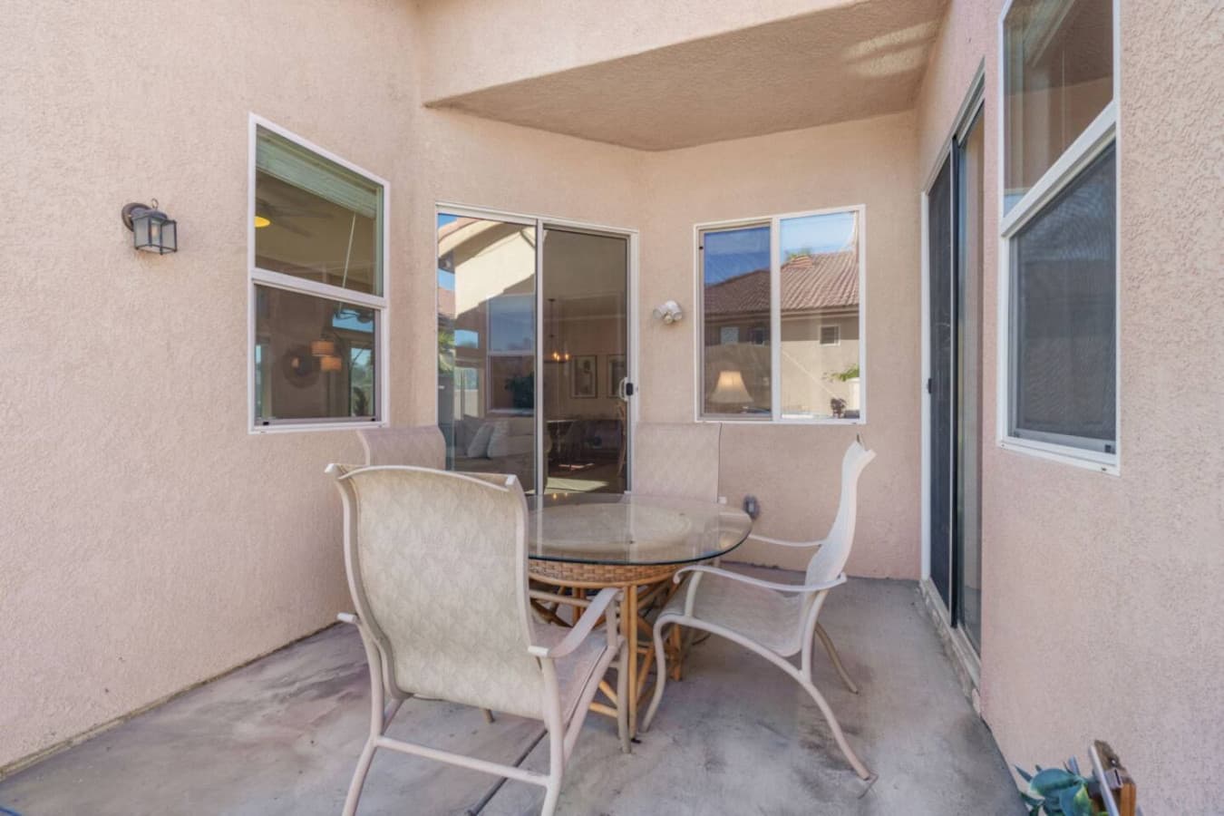 Covered patio seating w/ grill nearby, great for casual meals and outdoor downtime.