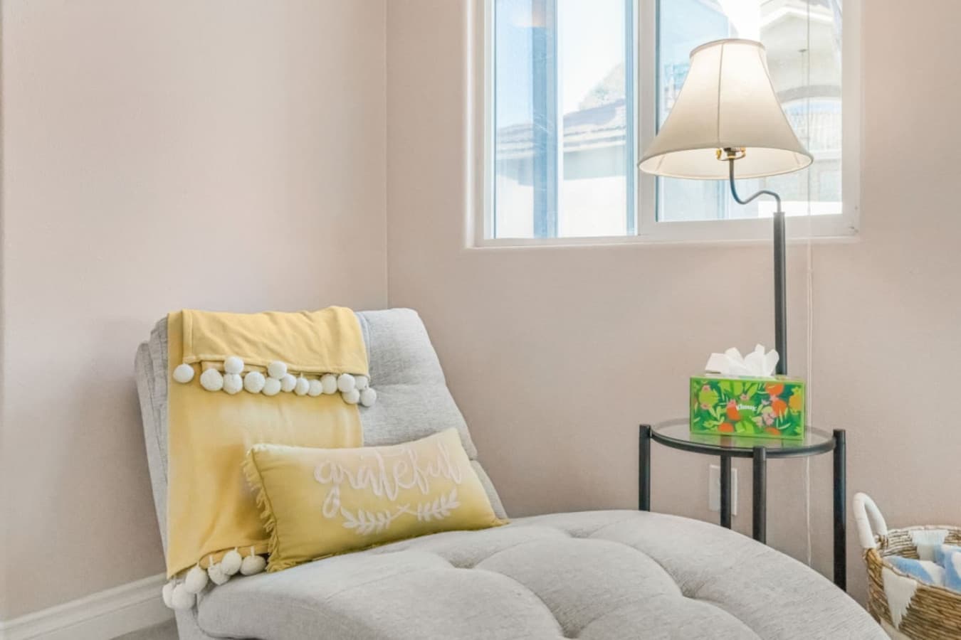 Quiet corner w/ accent chair and pillow, offering a cozy spot to read or unwind.
