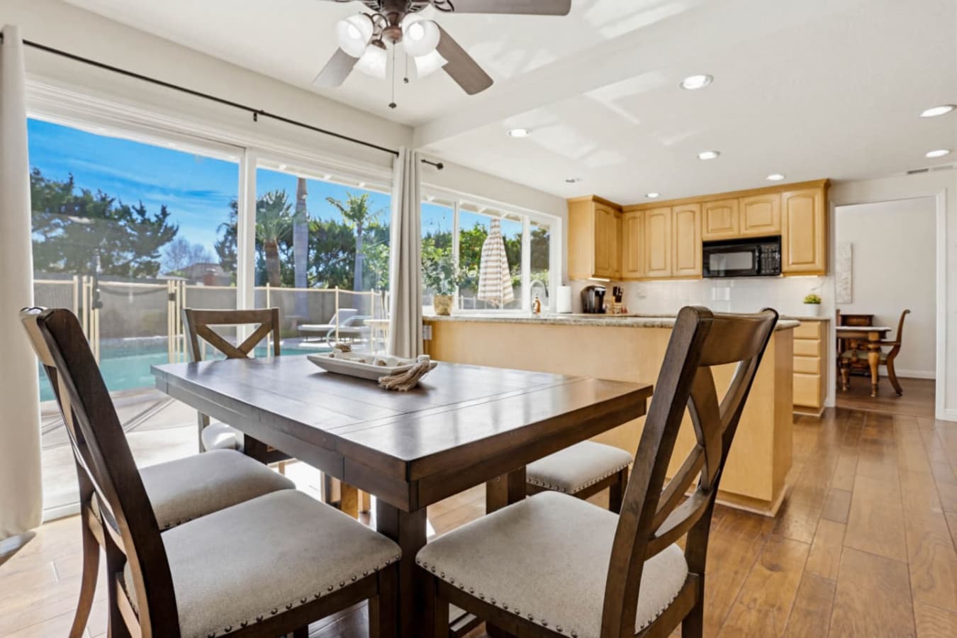 Open dining area w/ large table beside a bright kitchen, ideal for shared meals & conversation
