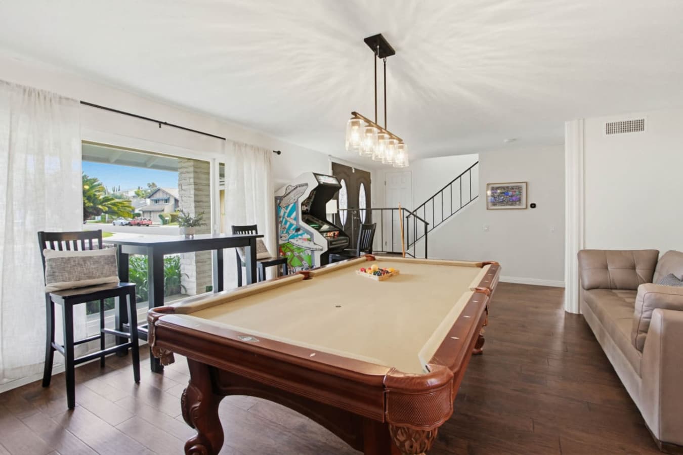 Game area w/ pool table, bar seating & large windows bringing in natural light