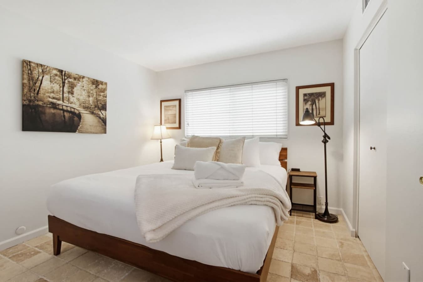 Cozy bedroom w/ soft bedding, nightstands & window light for a restful stay
