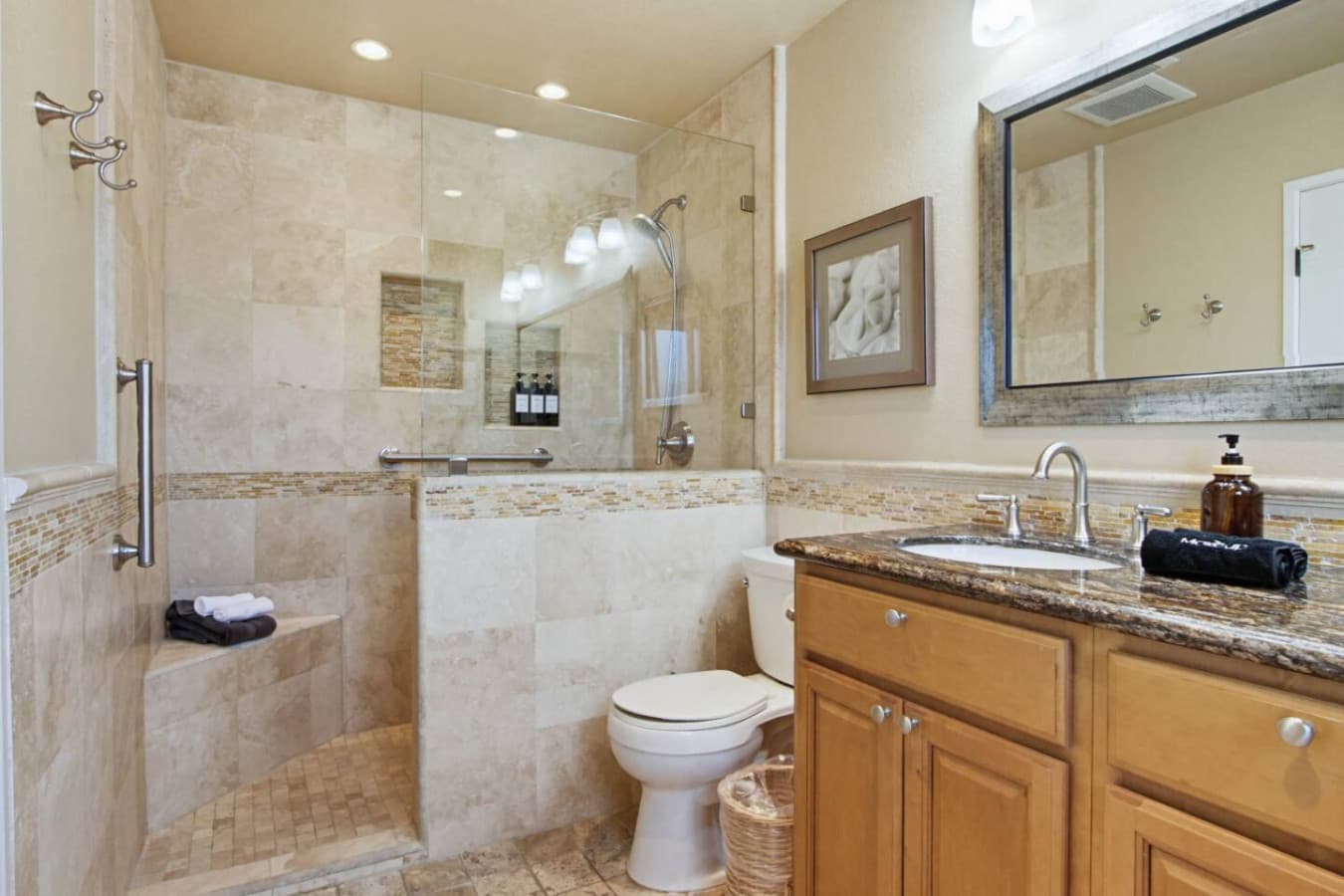 Bathroom w/ walk-in tiled shower, built-in bench & vanity for an easy rinse after the pool.
