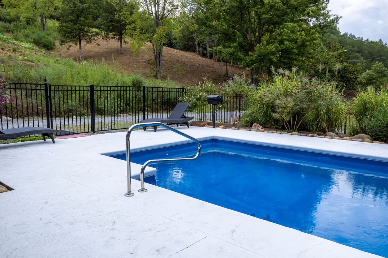 Poolside Fun: A wide-angle shot showing the proximity of the pool to the deck and grill.