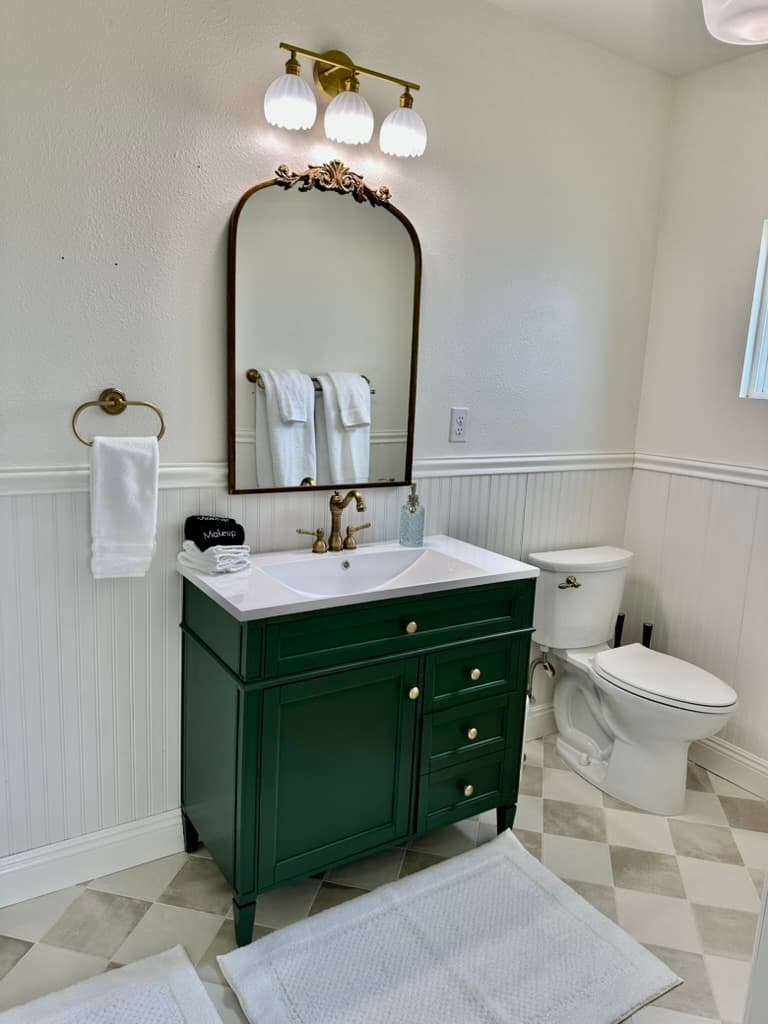 This stylish cottage bath with harlequin floors and brass fixtures will help you get ready in style for a night out or day or sightseeing or just relaxing on property