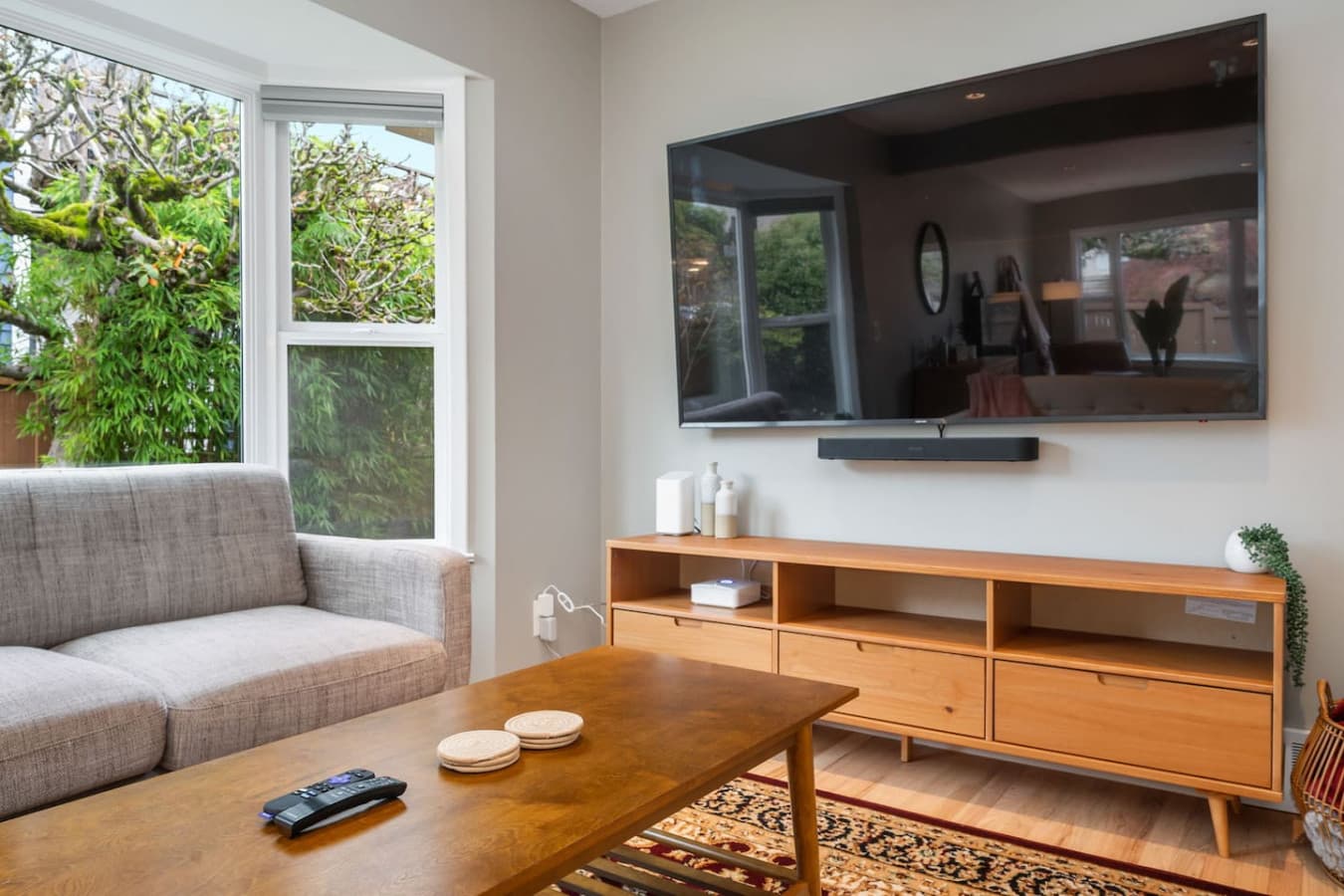 MAIN FLOOR: A smart TV and soundbar atop the sleek media console provide entertainment.