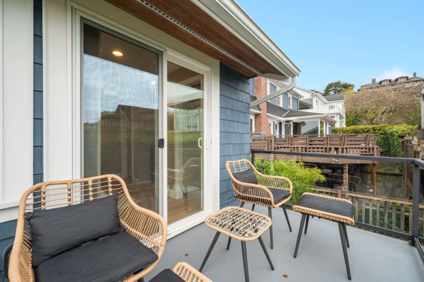 UPSTAIRS: This stylish balcony offers breathtaking views of the city skyline, Space Needle, and waterfront. Glass railings and lush greenery provide privacy while maintaining an open feel.