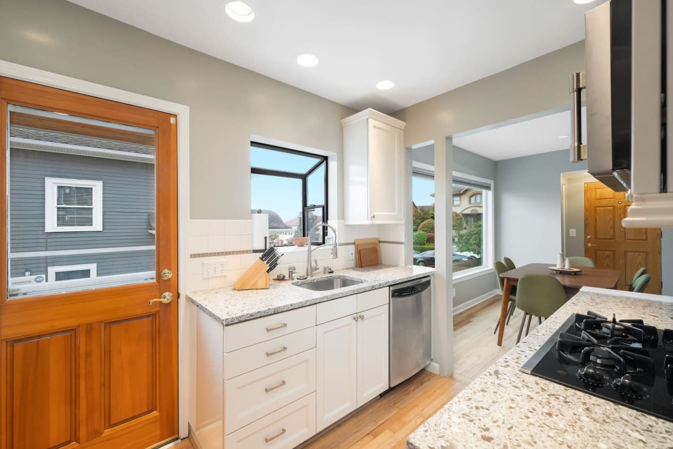 MAIN FLOOR KITCHEN: The wooden door with a glass panel provides direct access to the outdoor area, adding convenience and charm.