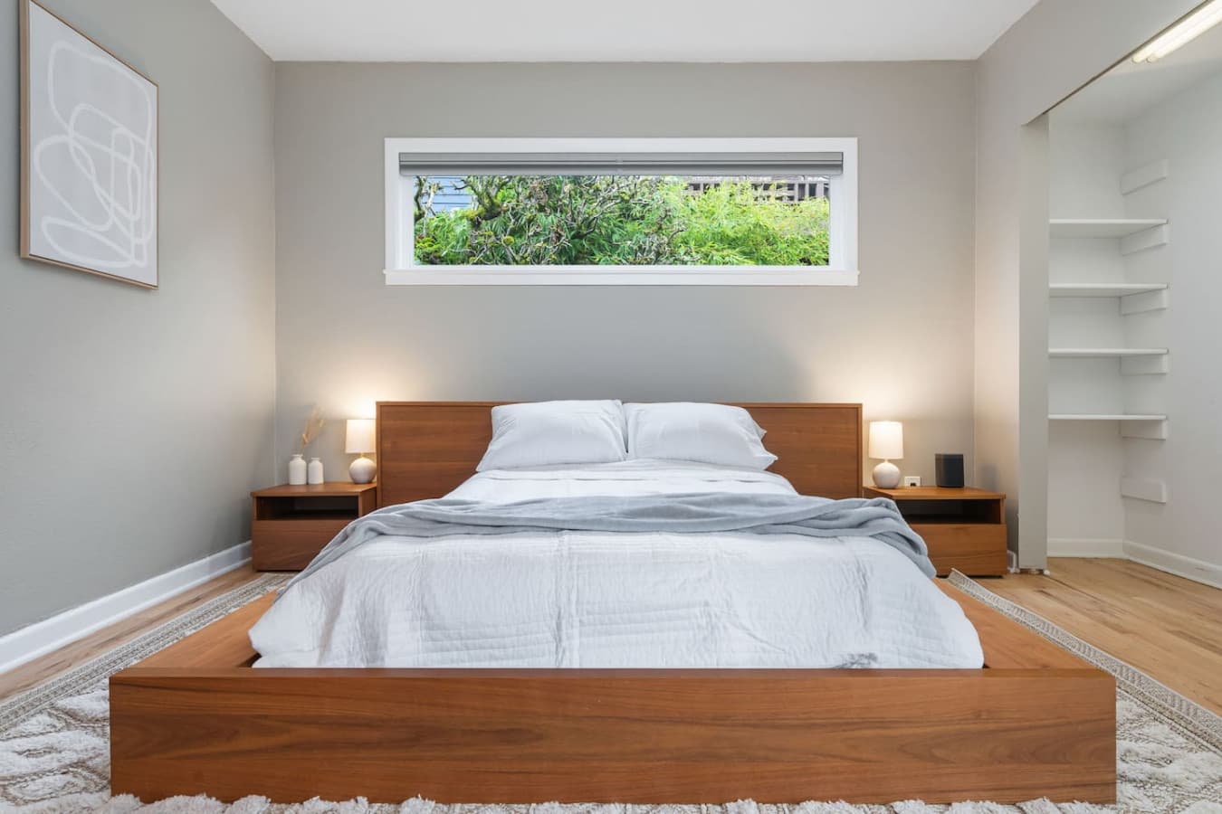 MAIN FLOOR - BEDROOM: A bed in a lower wooden style with a side table, featuring lamps and a Sonos One Smart Speaker Set of 2 Wi-Fi smart speakers with Alexa voice control.