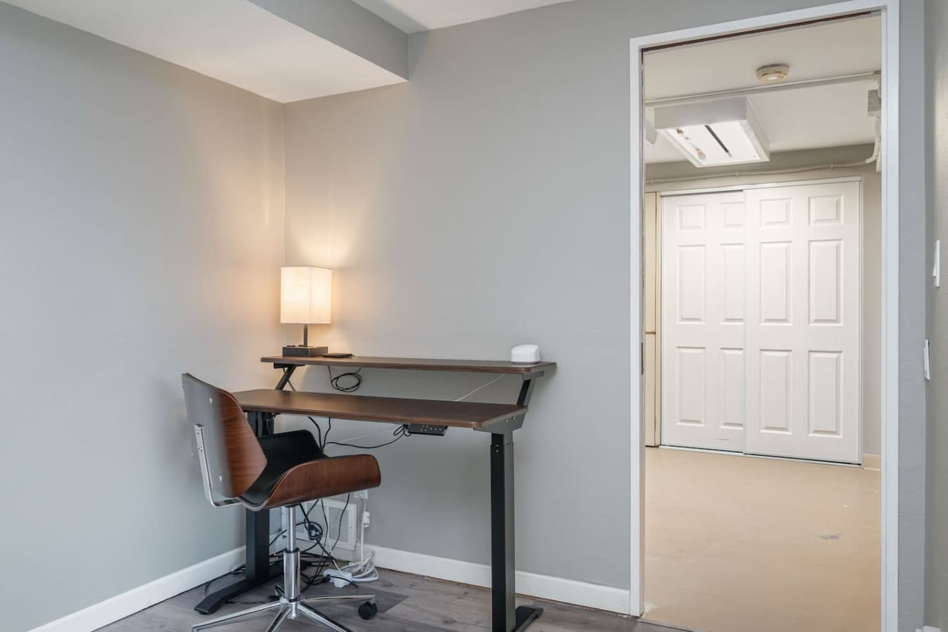 DOWNSTAIRS BEDROOM: It includes a dedicated workspace with an electric height-adjustable desk and an ergonomic office chair. The private bathroom offers a bathtub and shower. With a modern, minimalist design in neutral tones, the space feels both sop