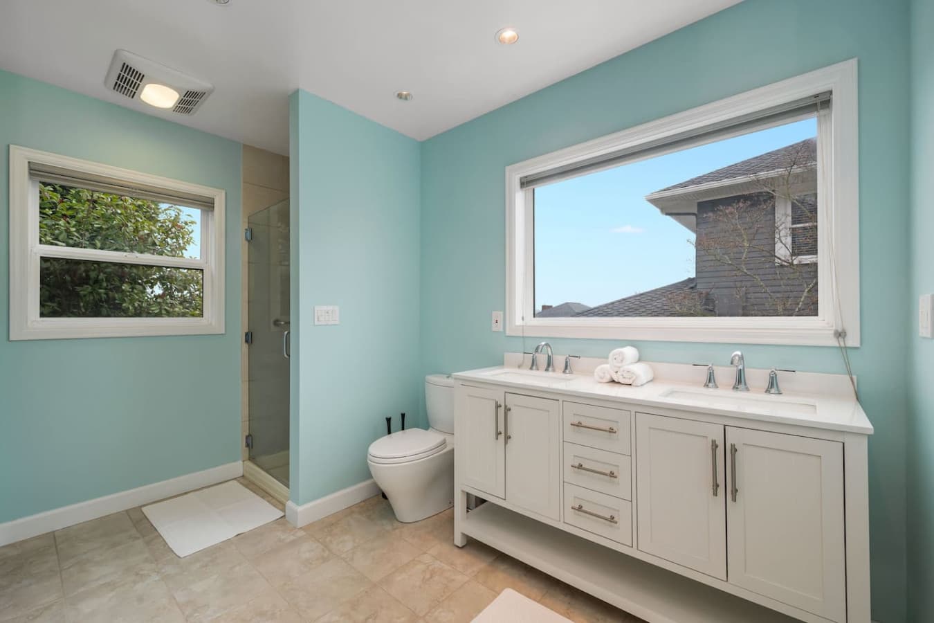 MAIN FLOOR BATHROOM: The private bathroom provides modern comfort and convenience, boasting a spacious shower, high-quality fixtures, and plush towels.