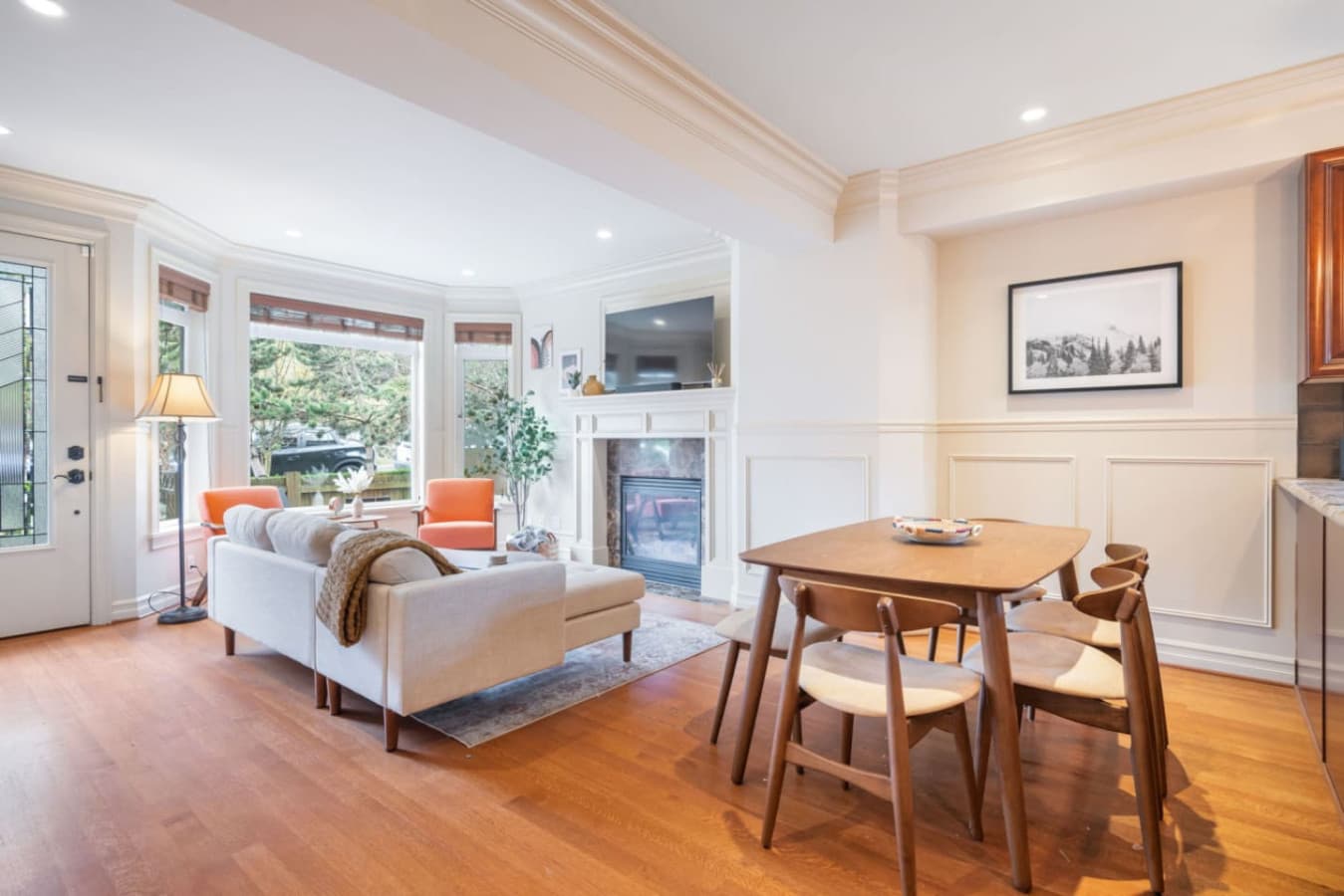 A warm and elegant living space with a cozy fireplace, picturesque bay windows, and inviting furnishings, perfect for intimate moments and relaxation.