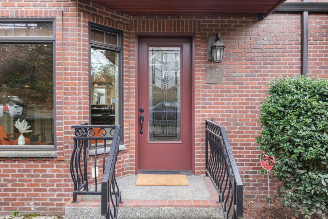 A short staircase with a stylish wrought-iron railing leads up to the entrance, adding a charming architectural detail to the space.