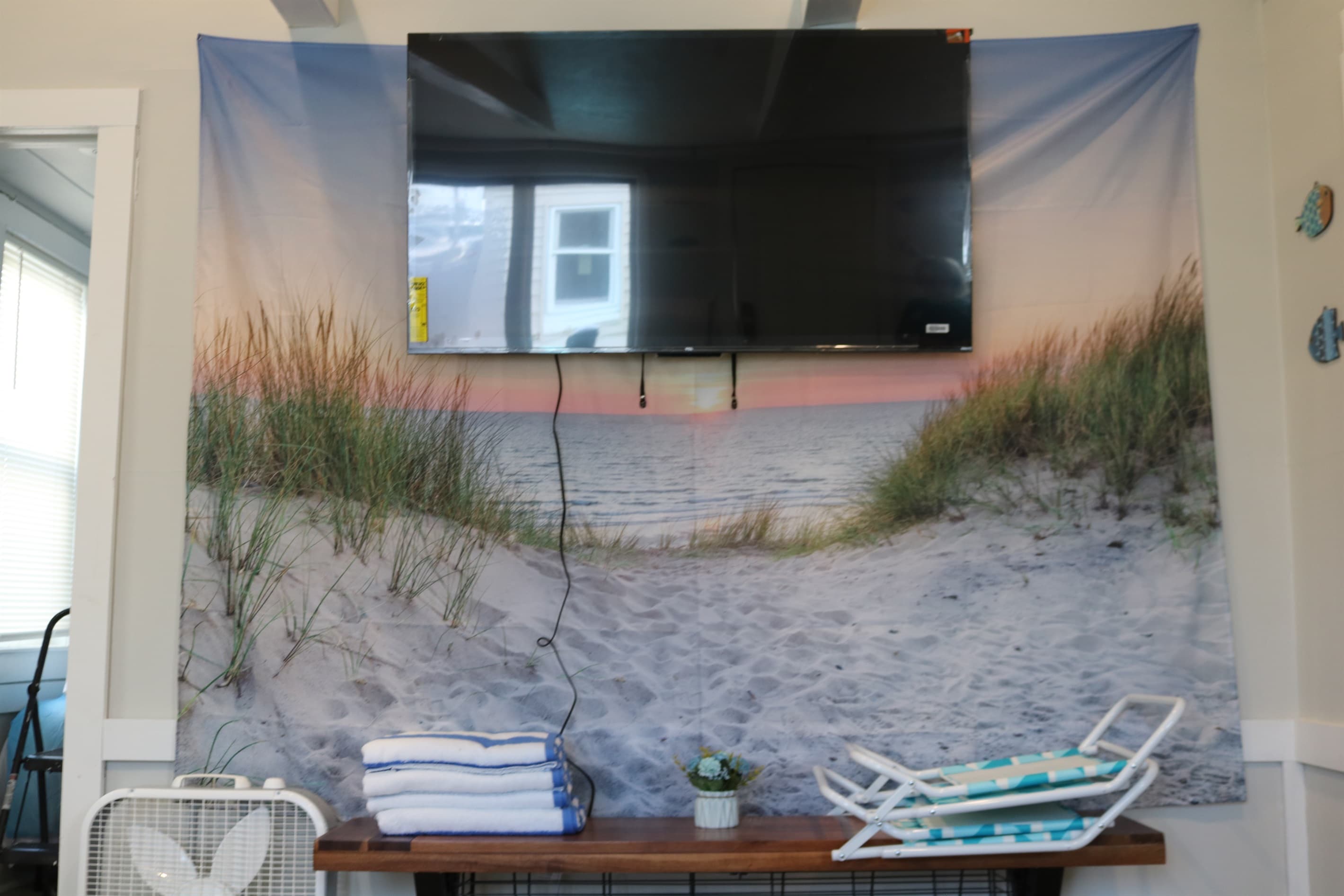 living room 55" Roku Smart TV and bench TV stand holding your beach chairs and towels