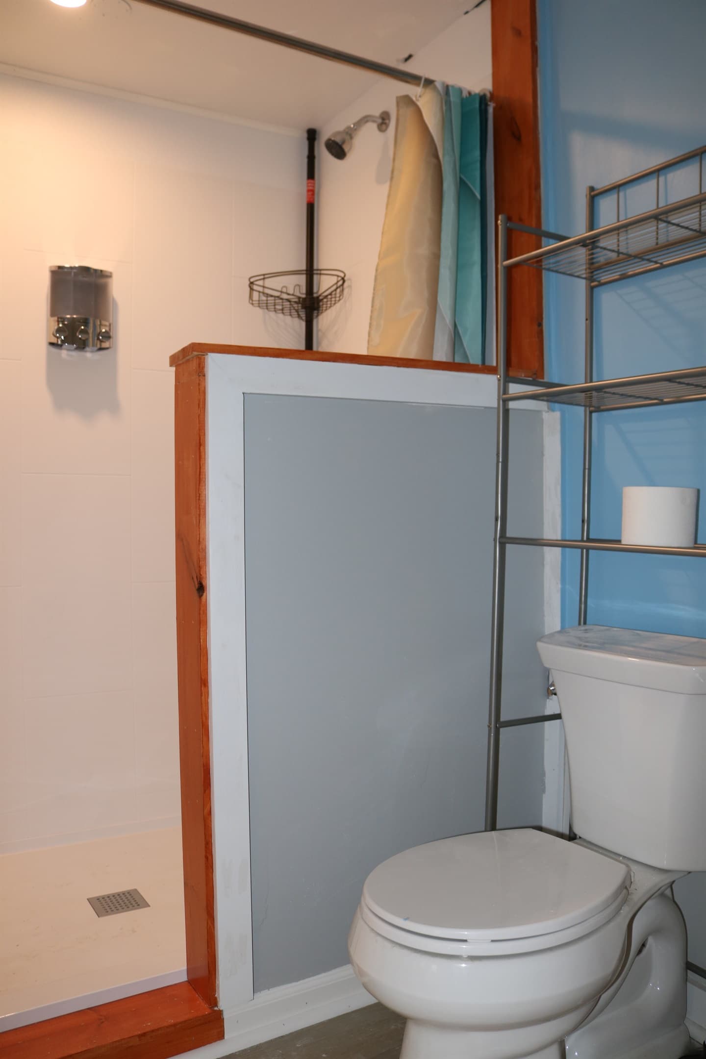 a beautiful half wall separates the rest of the bathroom from your shower