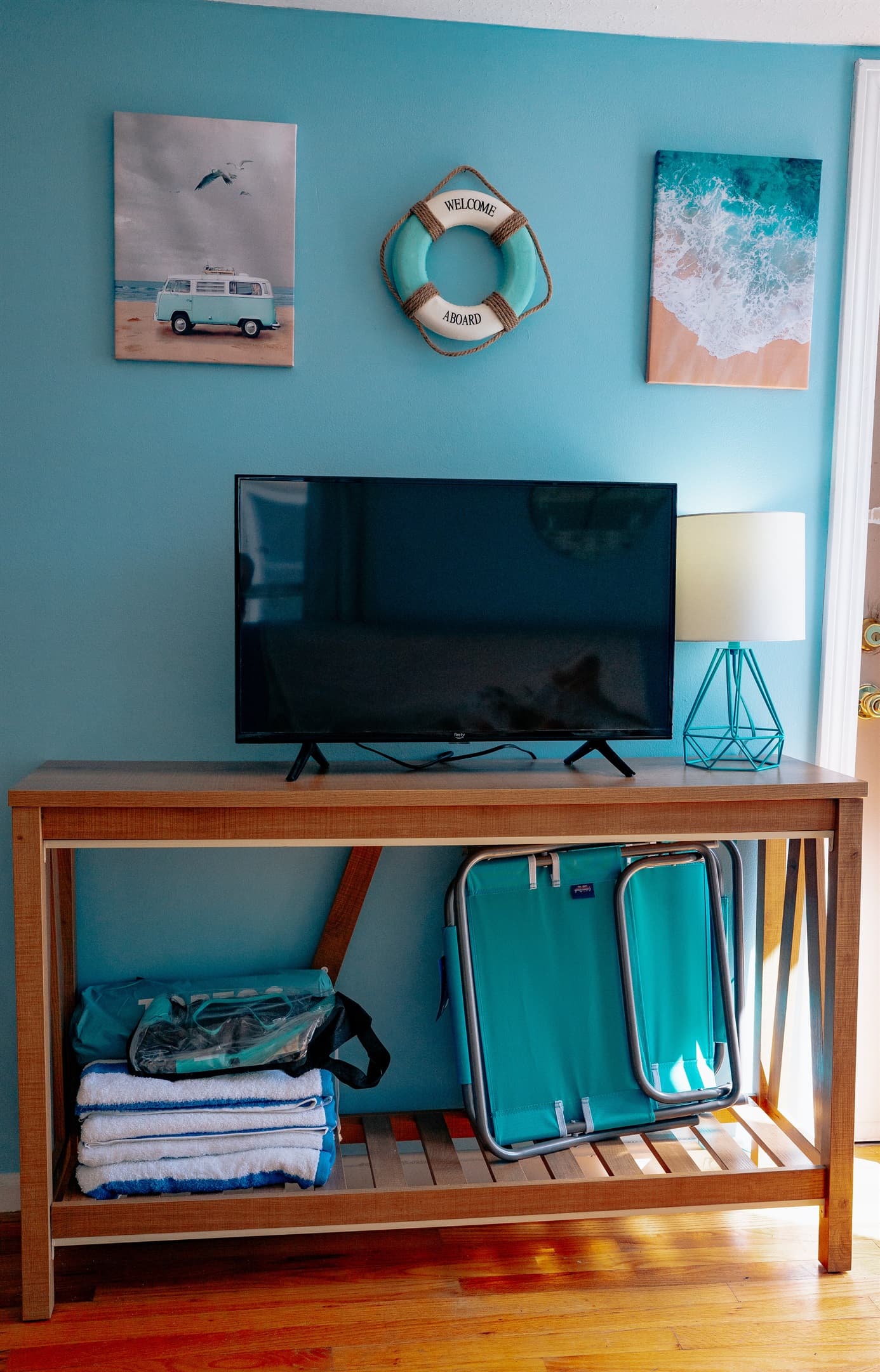 the tv stand in the living room, which includes beach towels, beach chairs, snorkel set & pop up tent