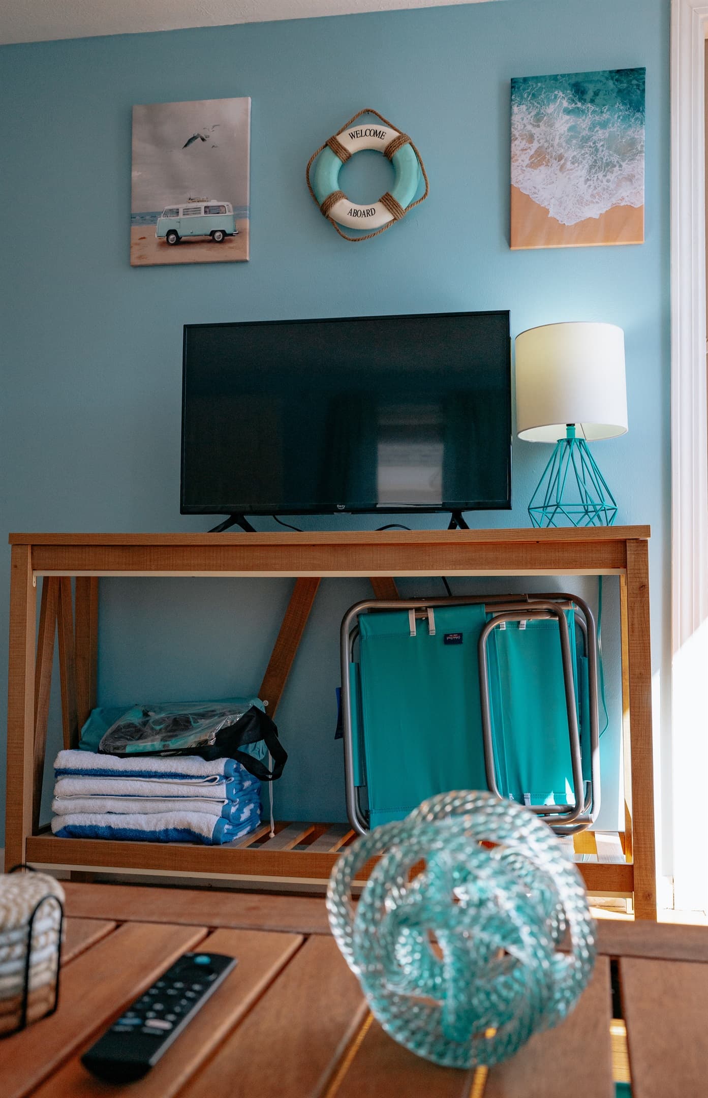 the tv stand in the living room, which includes beach towels, beach chairs, snorkel set & pop up tent