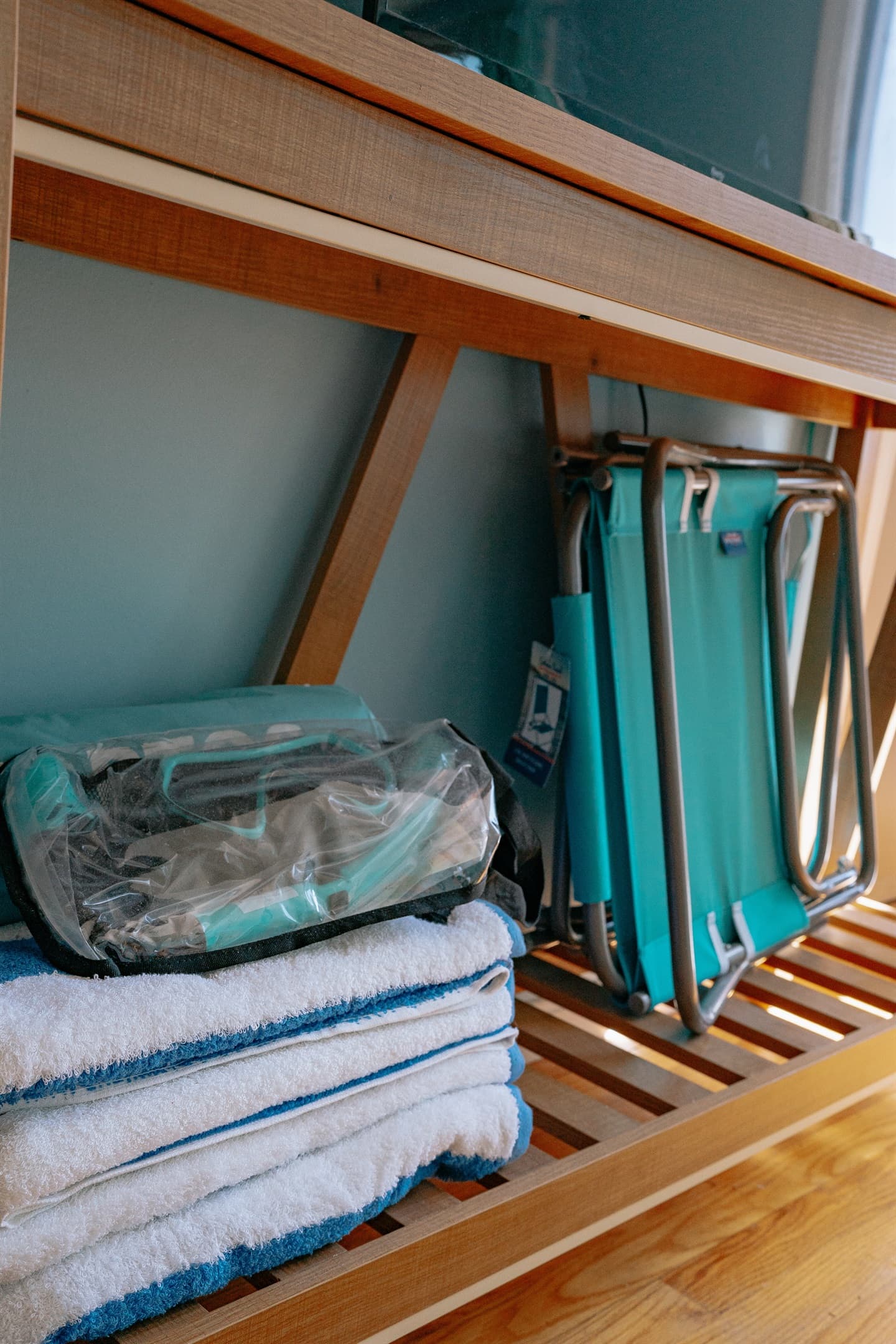 the tv stand in the living room, which includes beach towels, beach chairs, snorkel set & pop up tent
