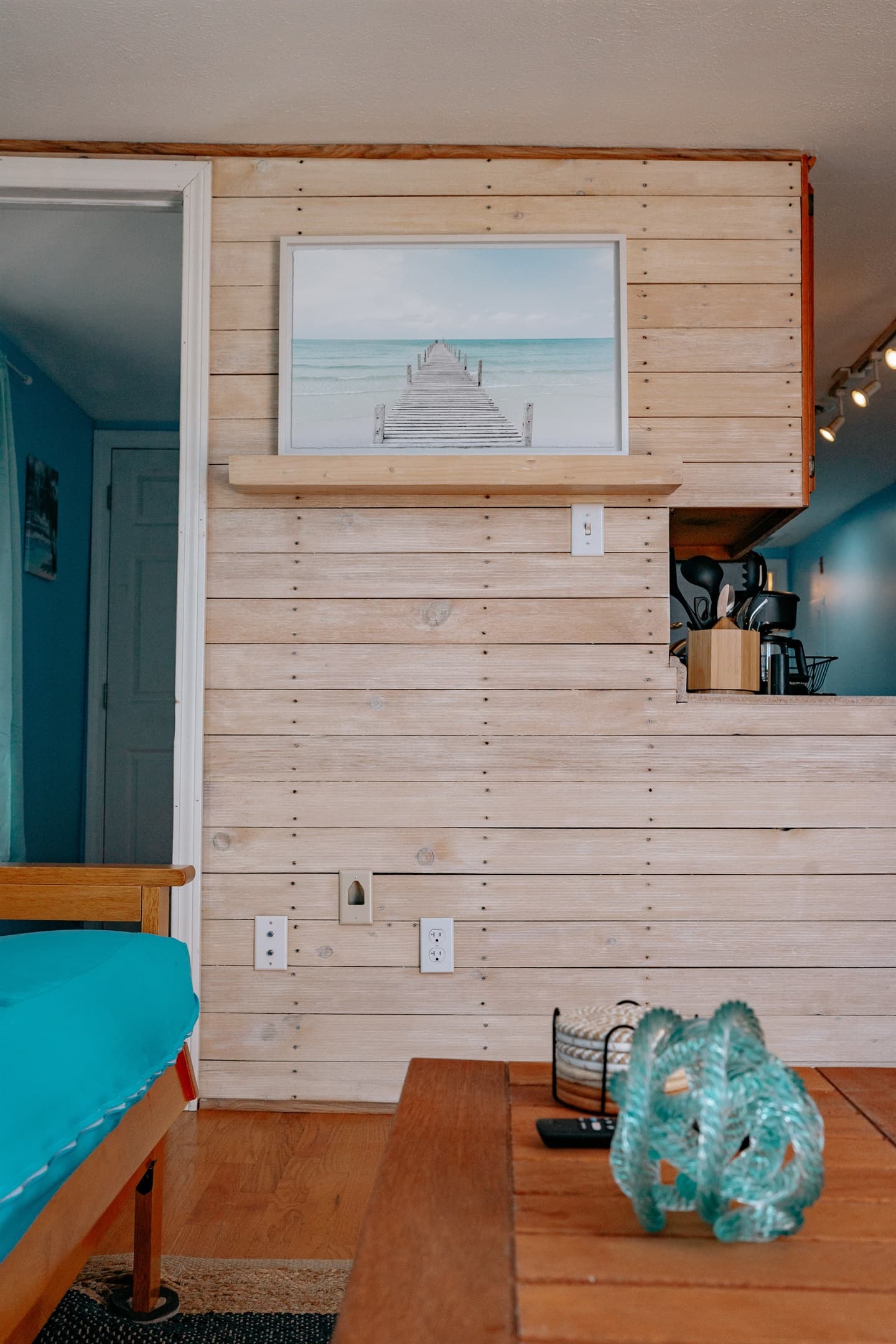 the white washed wall in the living room, looking into the guest bedroom and kitchen
