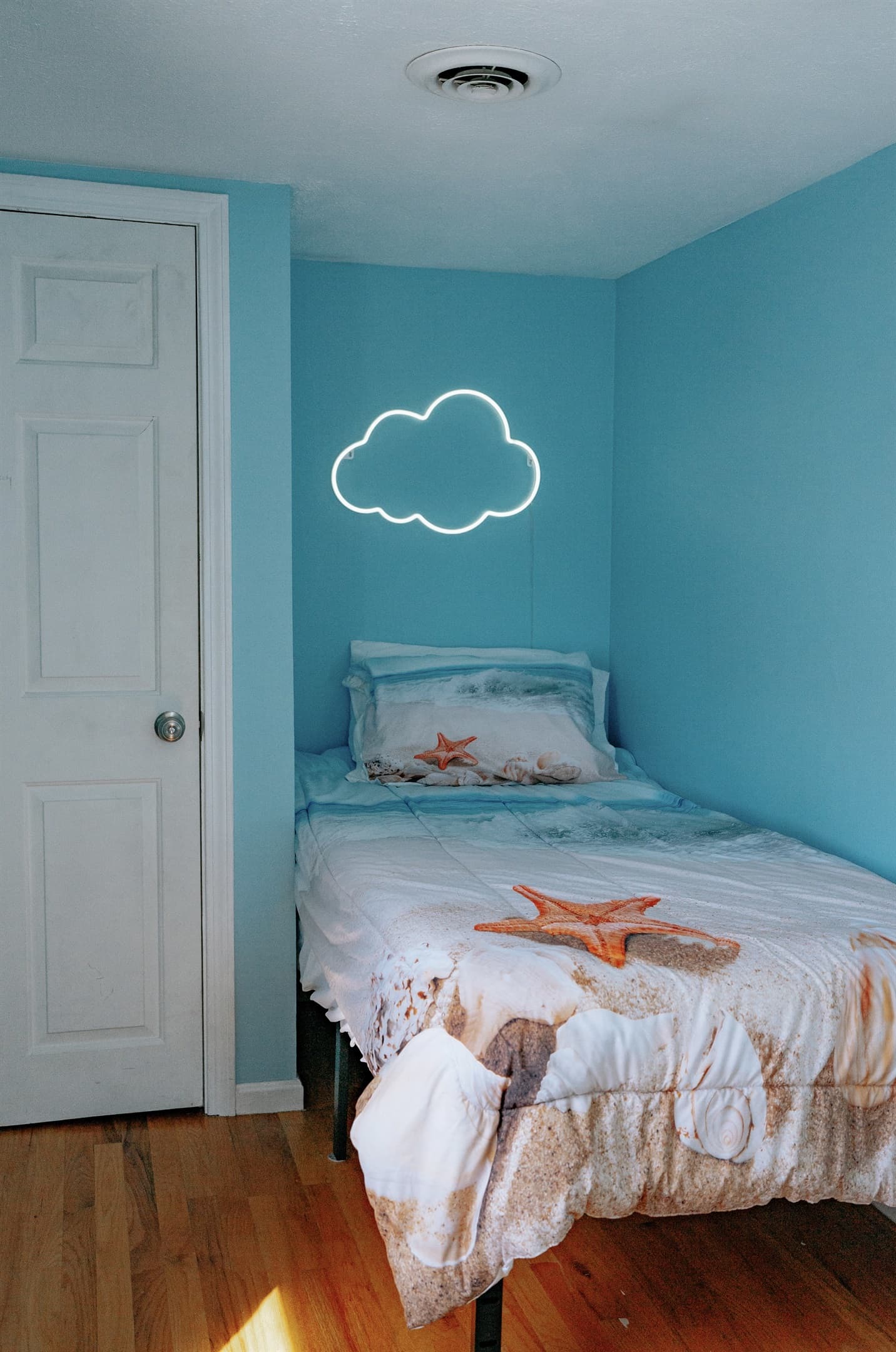 the guest bedroom has a twin bed, led lighting, closet with hangars, extra blankets and pillows, and has a window air conditioner unit during the season