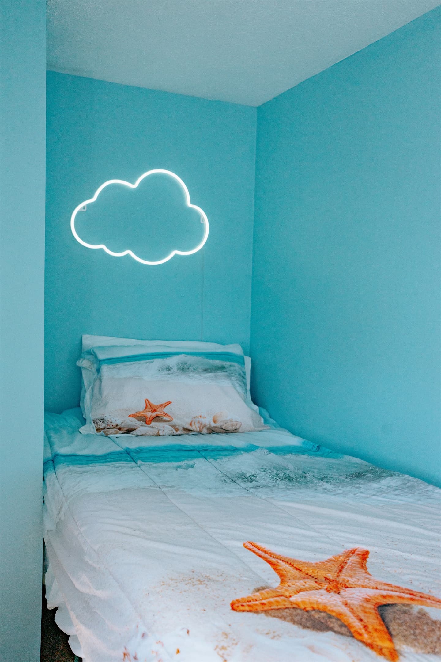 the guest bedroom has a twin bed, led lighting, closet with hangars, extra blankets and pillows, and has a window air conditioner unit during the season