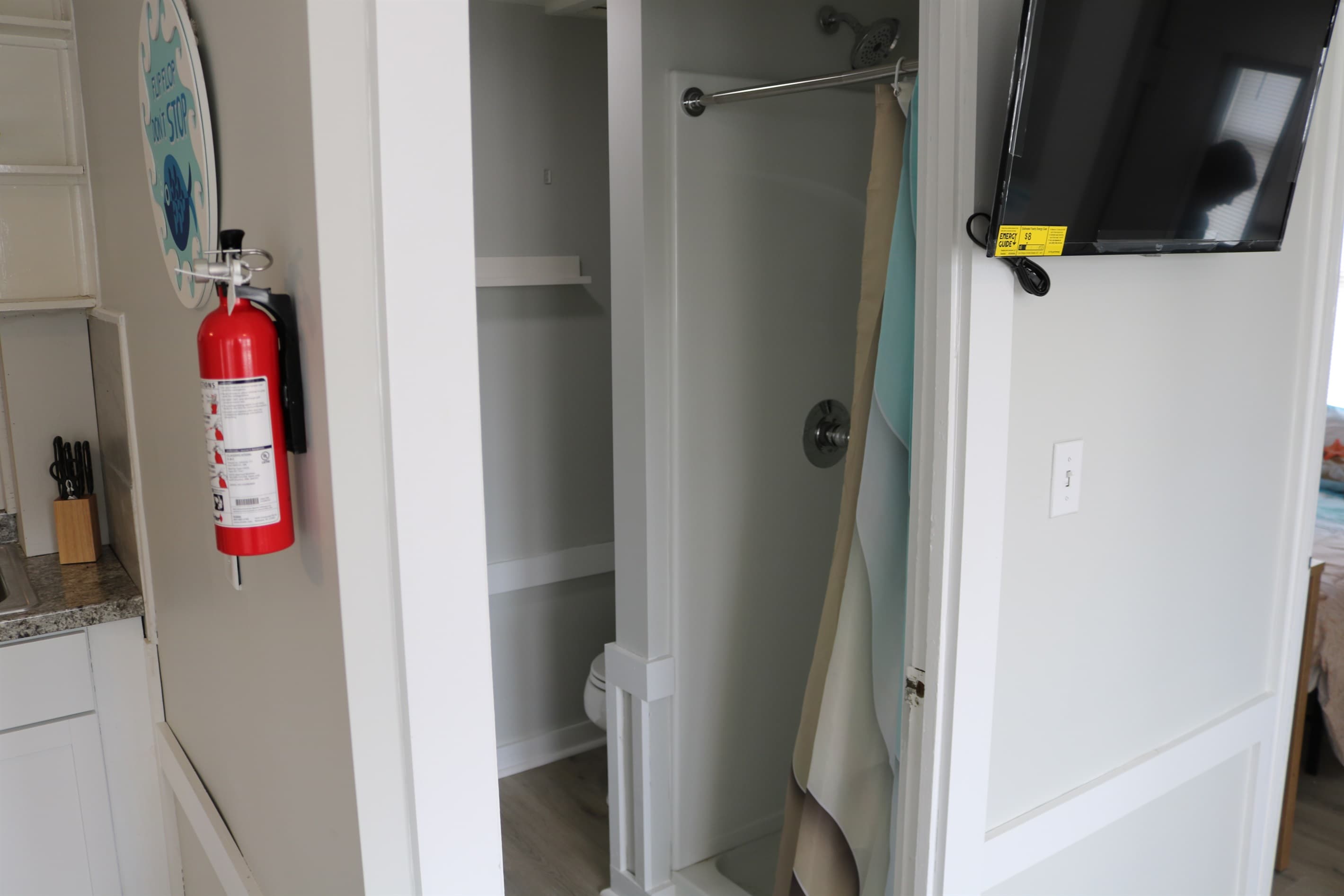 bathroom complete with sink and medicine cabinet.a 32" Amazon FIre TV is mounted to the wall for easy viewing in the living room.