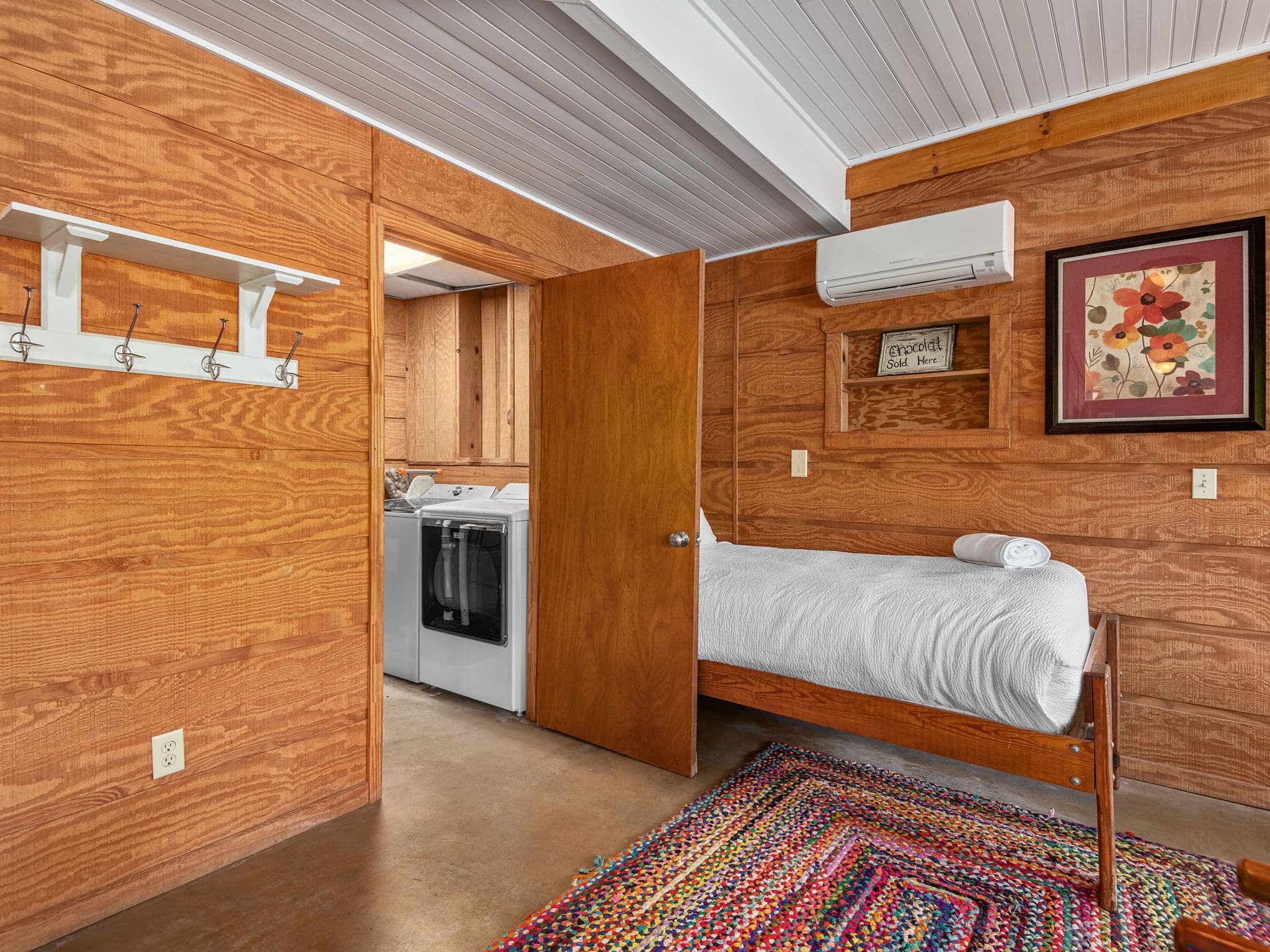 A view of the laundry room with another twin bed on the lower level.