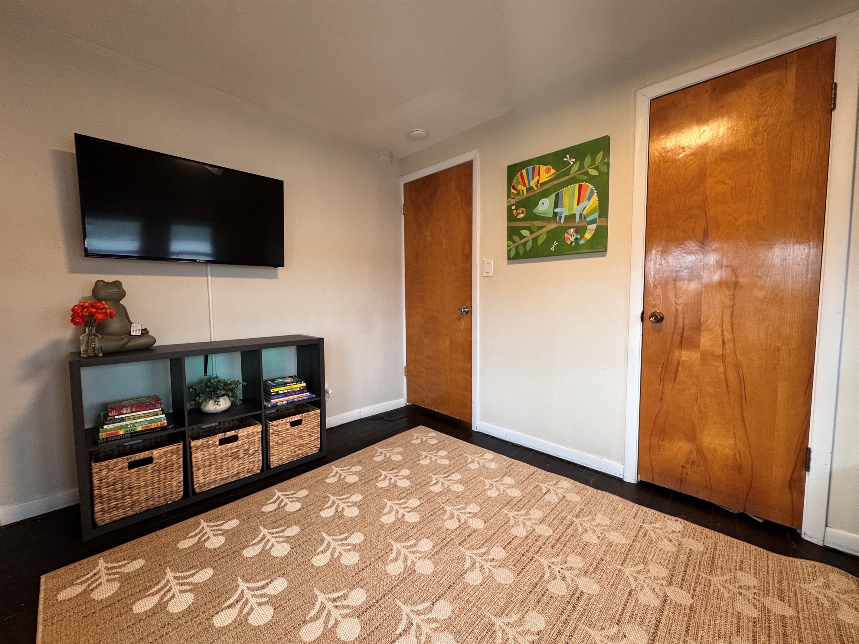 TV and cute backlit cubbies with books and linens for however you want beds set up.