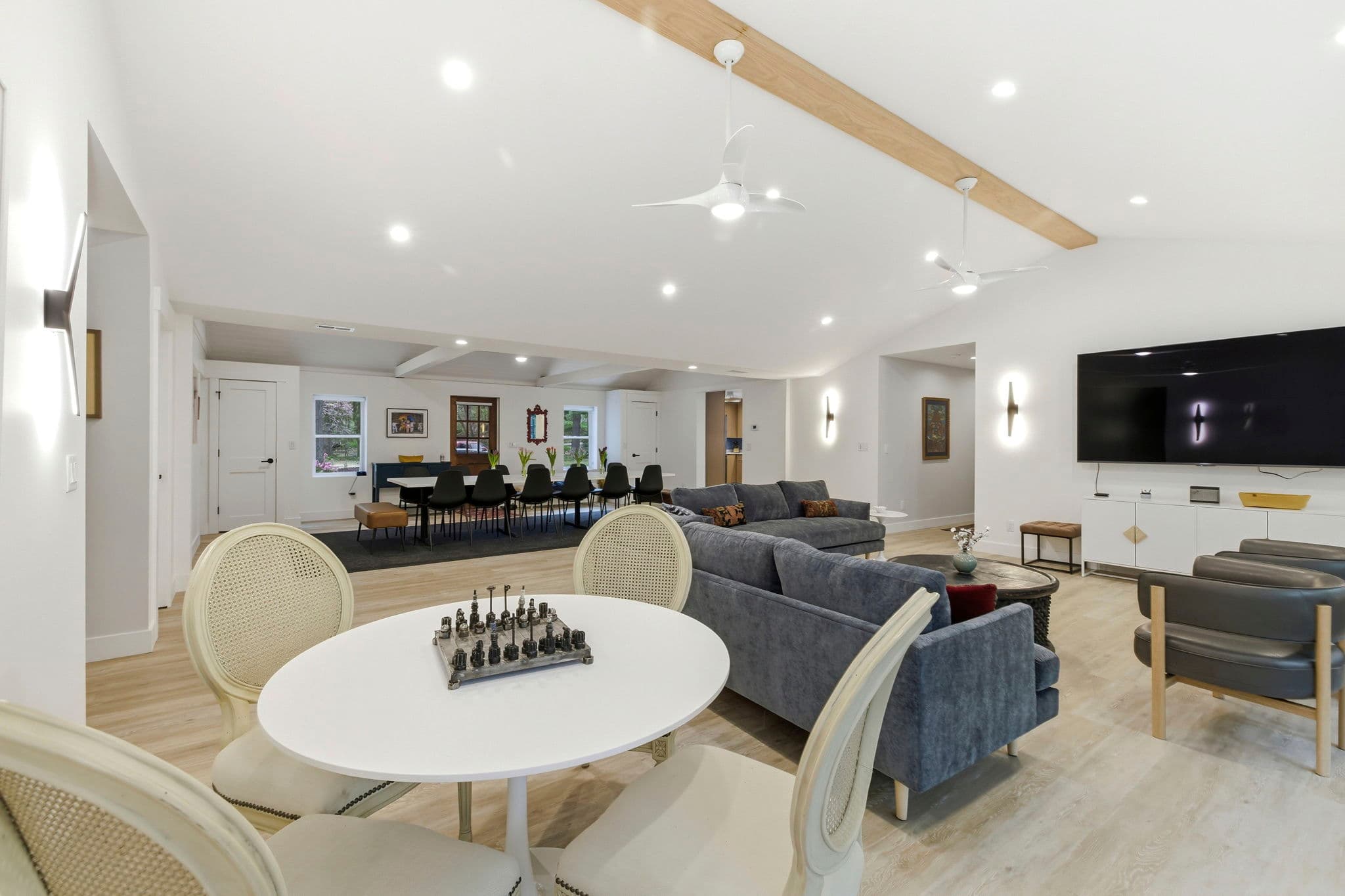 The living room has an 85" flat screen TV. Game table at right.