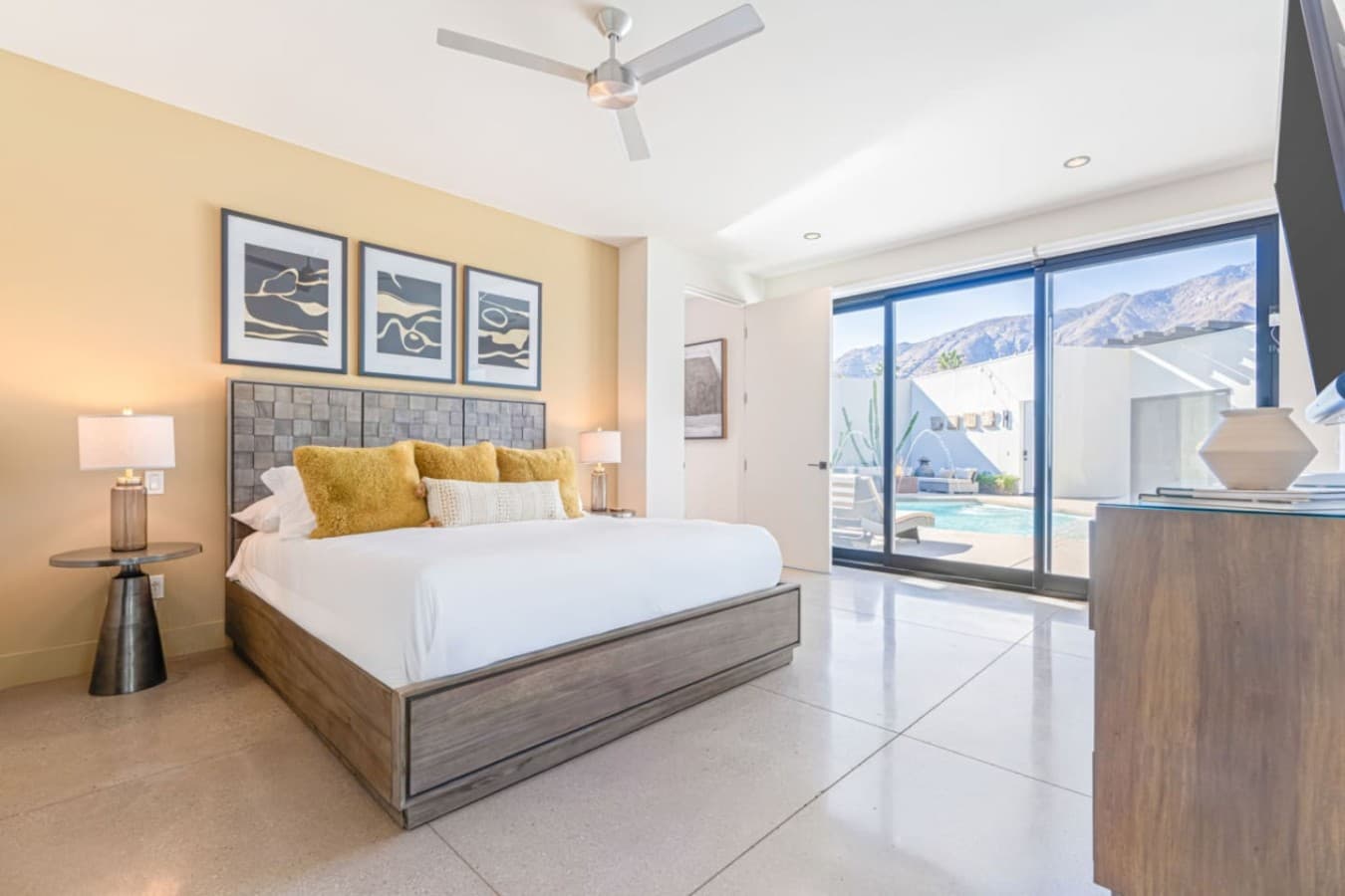 Calm bedroom retreat w/ plush bed, soft tones, and sliding doors opening to natural light.