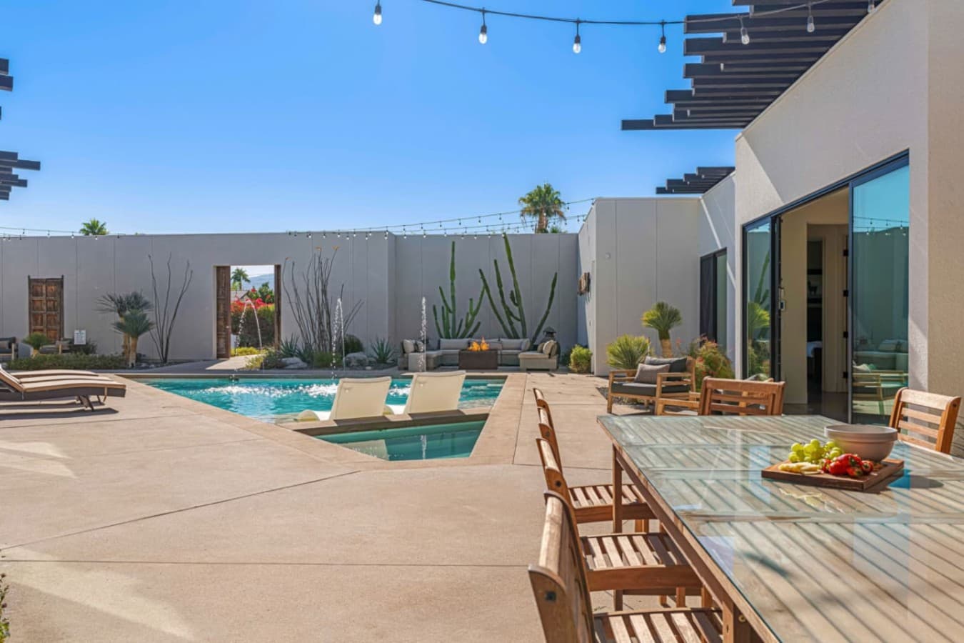 Wide-open backyard w/ pool, loungers, and clean desert walls made for sunny days & casual outdoor hangs.