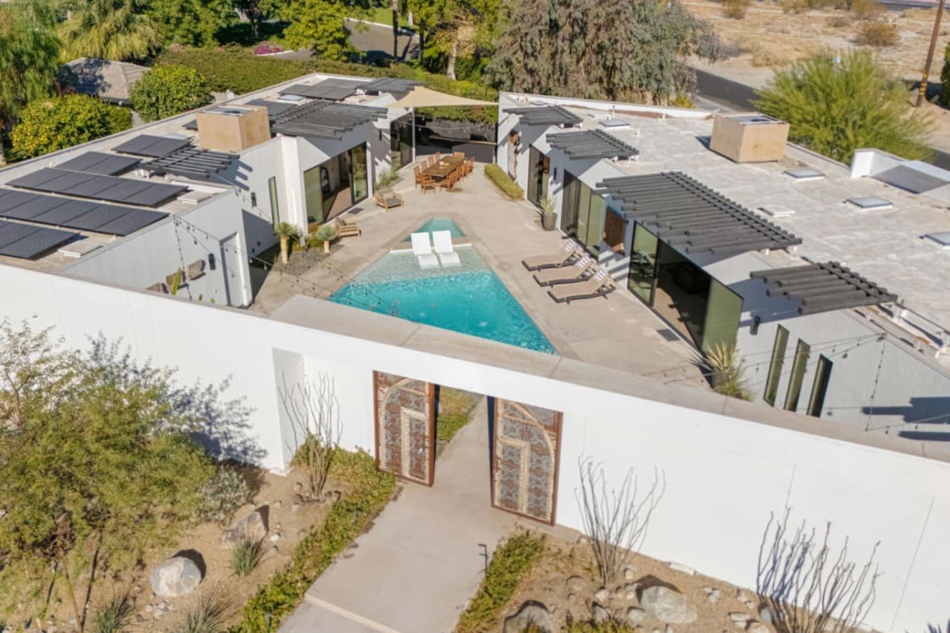 Aerial view of the home highlighting the private pool, walled courtyard, and seamless indoor-outdoor layout.