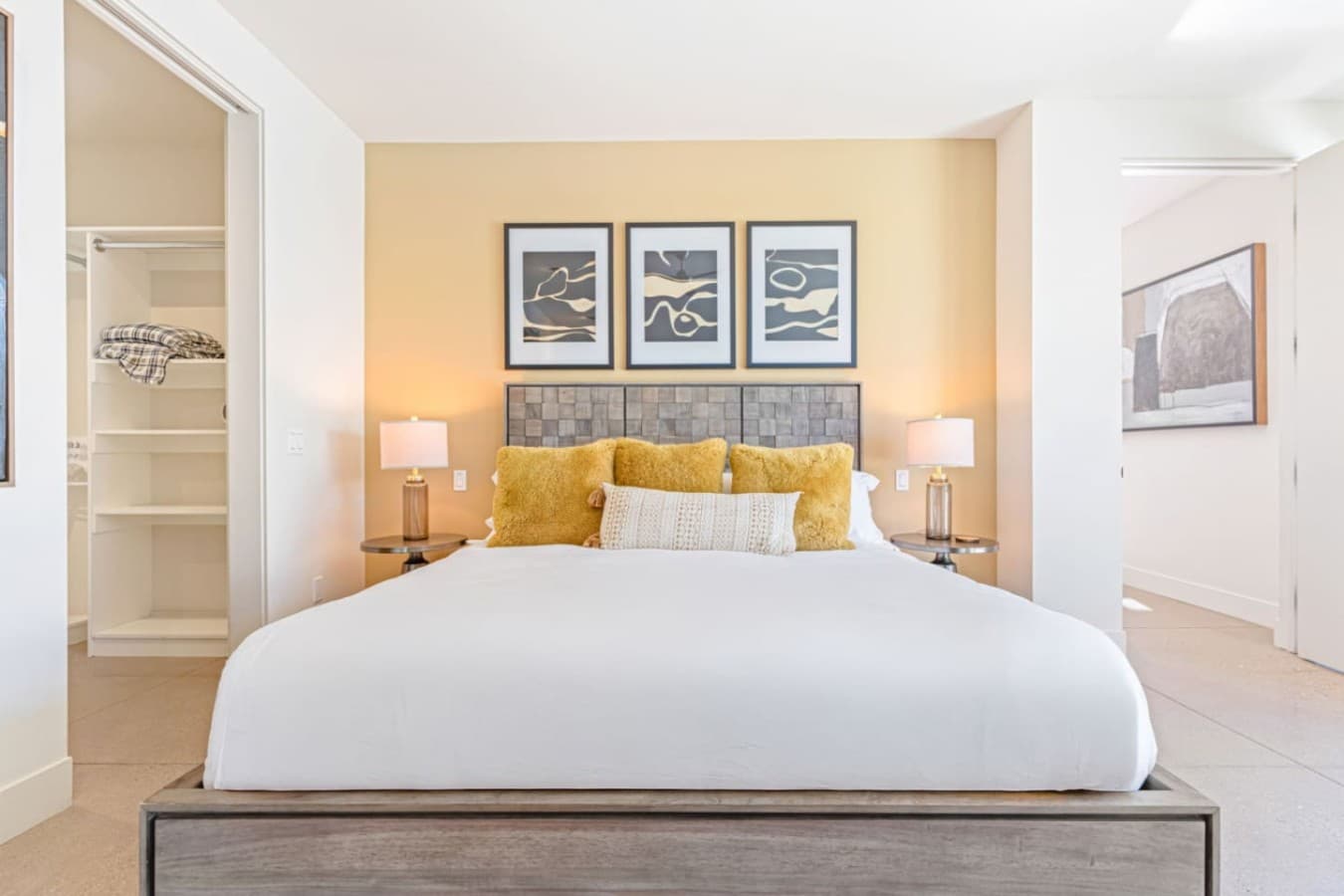 Inviting bedroom w/ soft linens, framed art, and a calm palette for restful nights.