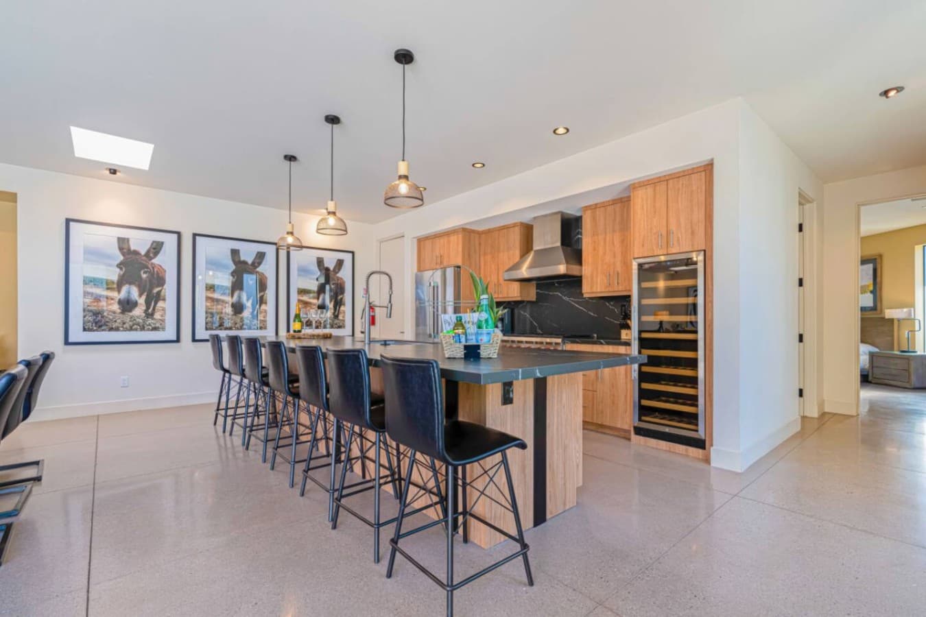 Chef-ready kitchen w/ expansive island, open shelving, and smooth flow into dining & living zones.