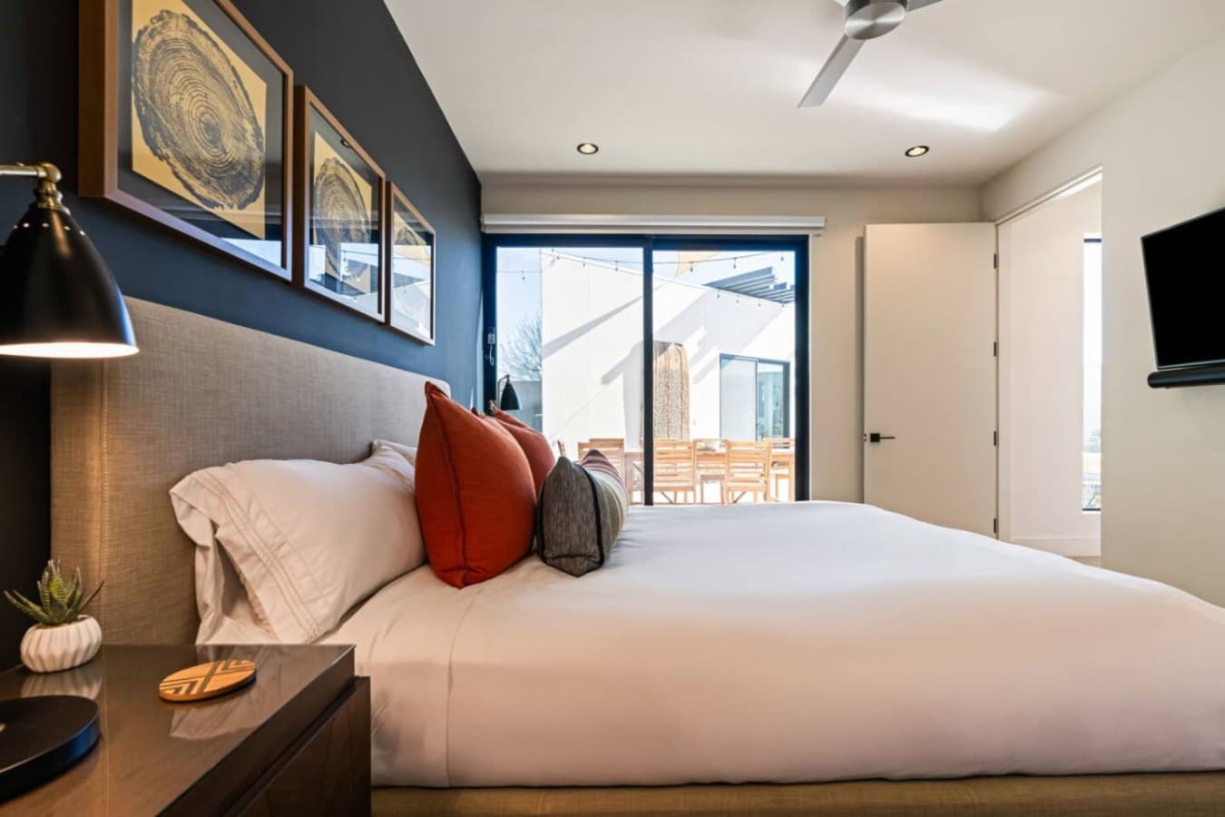 Serene bedroom w/ wood platform bed, warm accents, and soft lighting for easy nights in.
