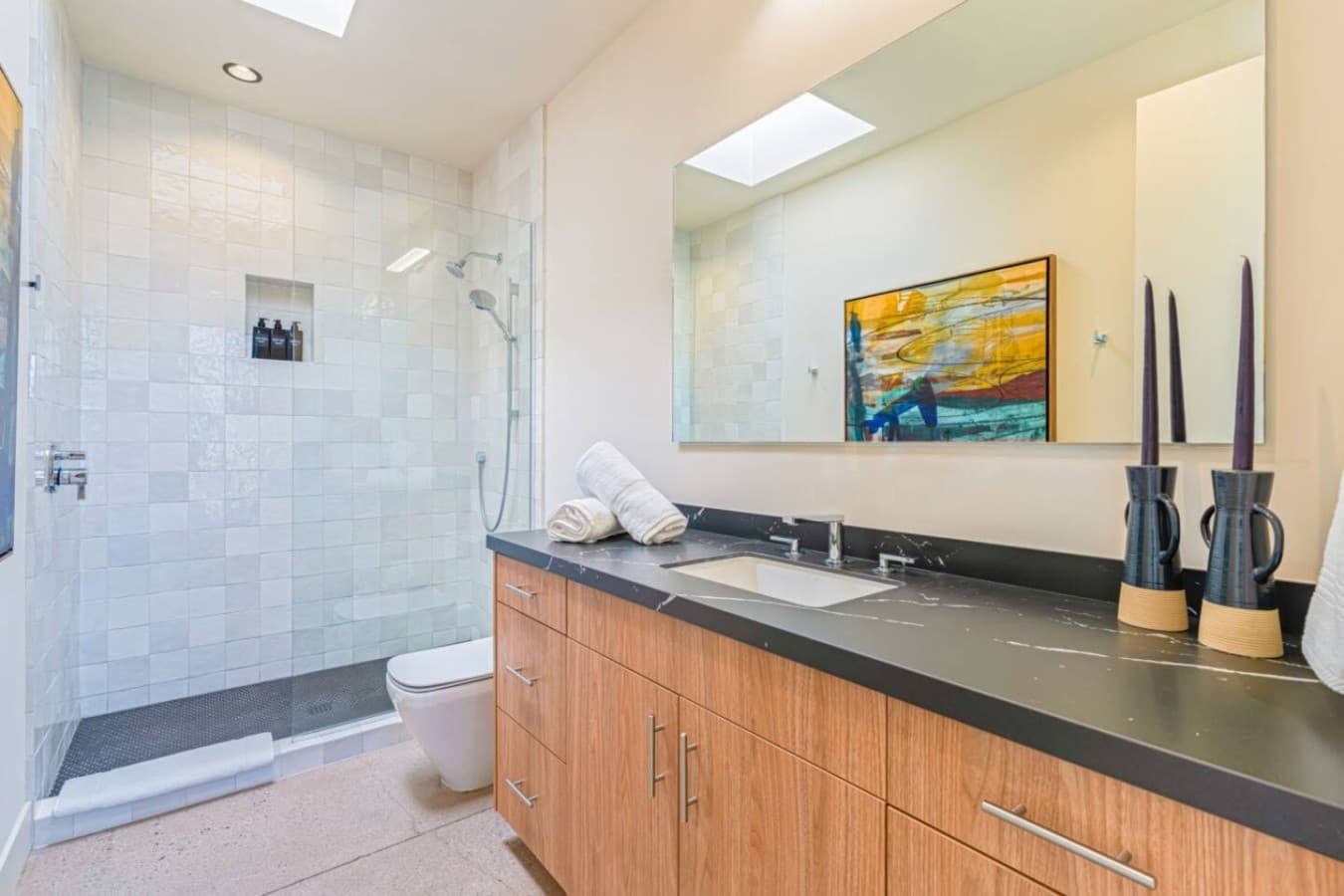 Spacious walk-in shower w/ glass enclosure, tile walls, and a calm, spa-inspired look.