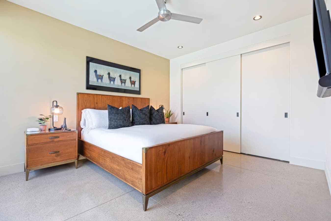 Comfortable bedroom w/ wood furniture, neutral tones, and plenty of open floor space.