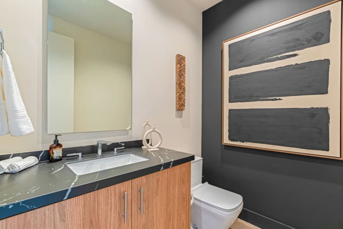 Sleek vanity area w/ modern fixtures, clean surfaces, and thoughtful decorative touches.