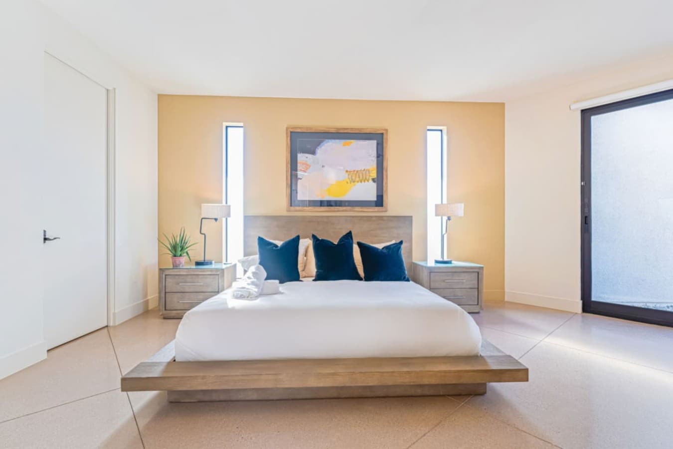 Bright bedroom retreat w/ plush bedding, warm wood details, and a peaceful, uncluttered feel.