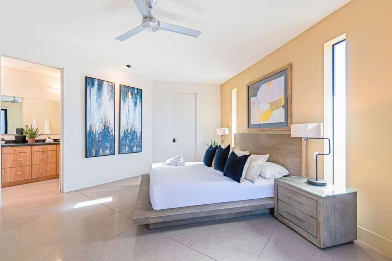 Bright bedroom retreat w/ crisp linens, framed art, and plenty of natural light.