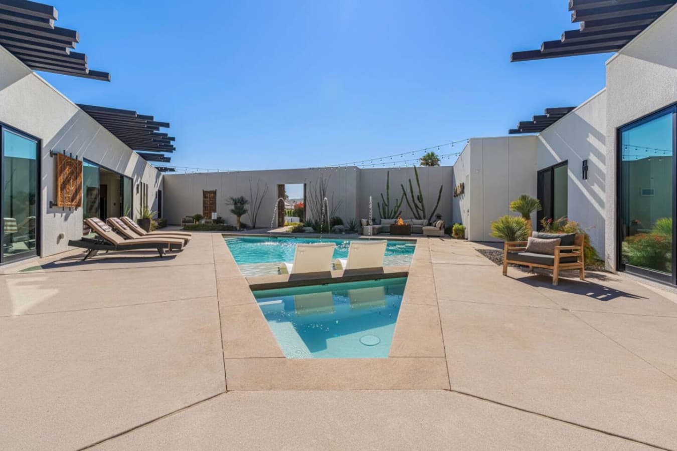 Central pool courtyard w/ loungers, palm trees, and open space to soak up the sun.