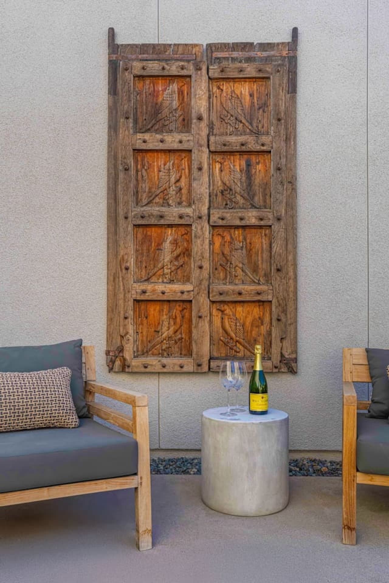 Rustic wood entry doors w/ natural texture and desert character making a warm first impression.