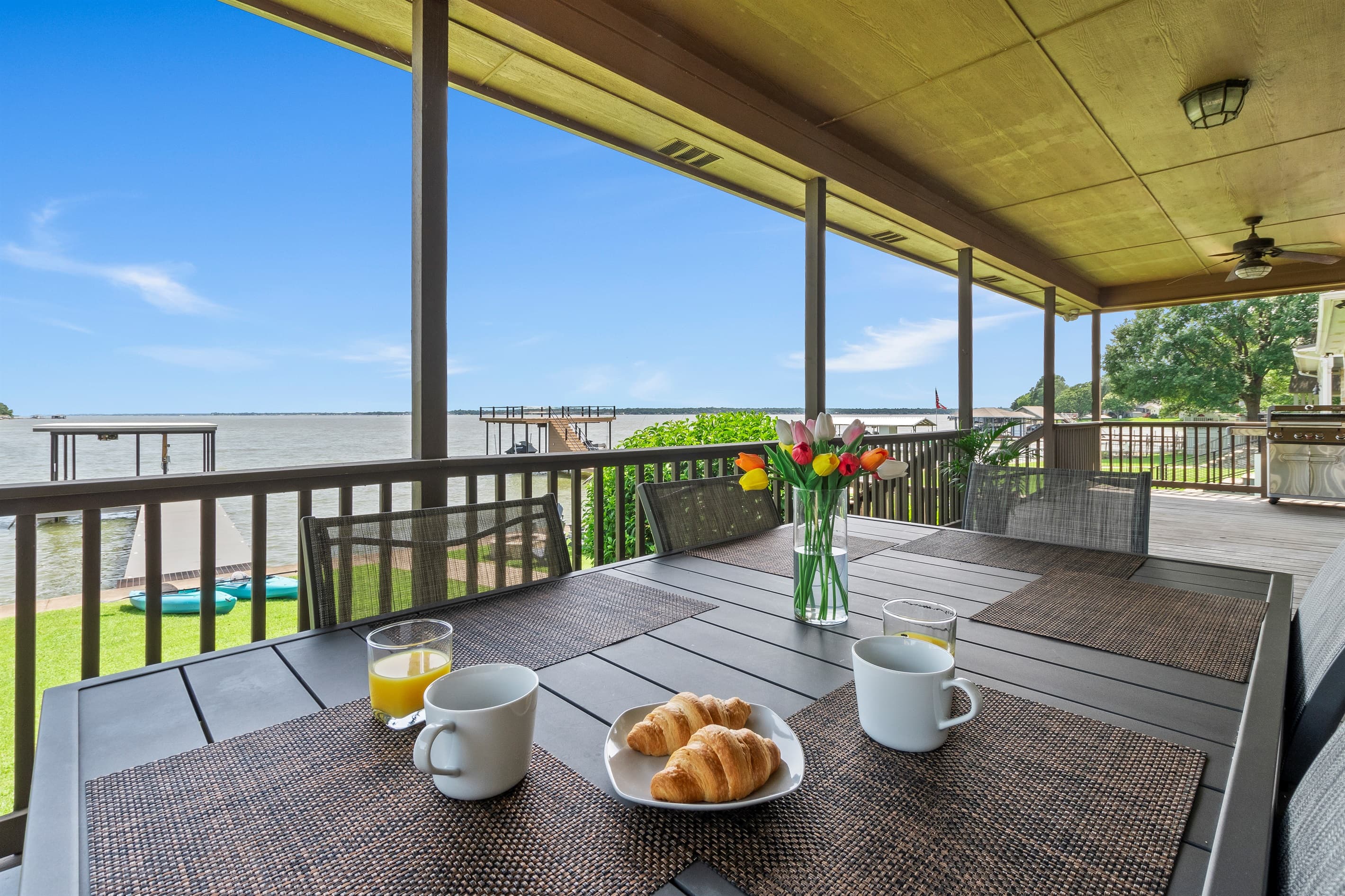 Massive covered porch with dining table, chairs and a grill.