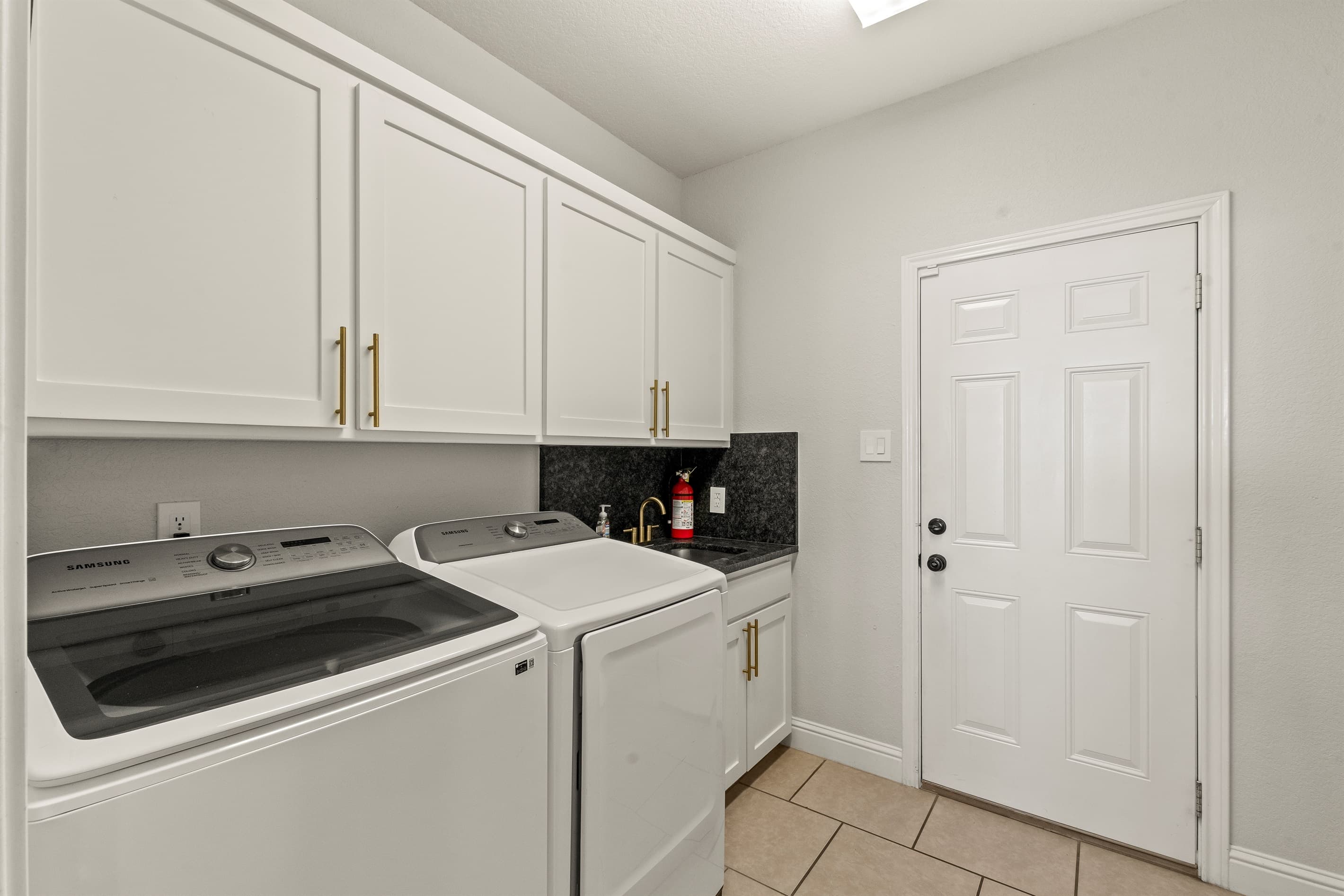 Convenient laundry room equipped with full-size washer and dryer for effortless living.