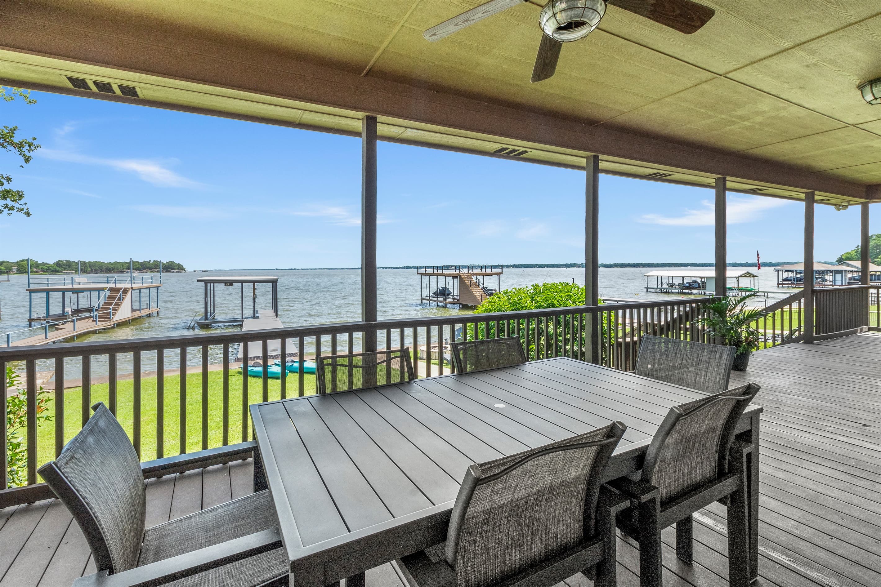 Massive covered porch featuring a dining table for eight and a grill—perfect for enjoying fresh air and stunning sunset views.