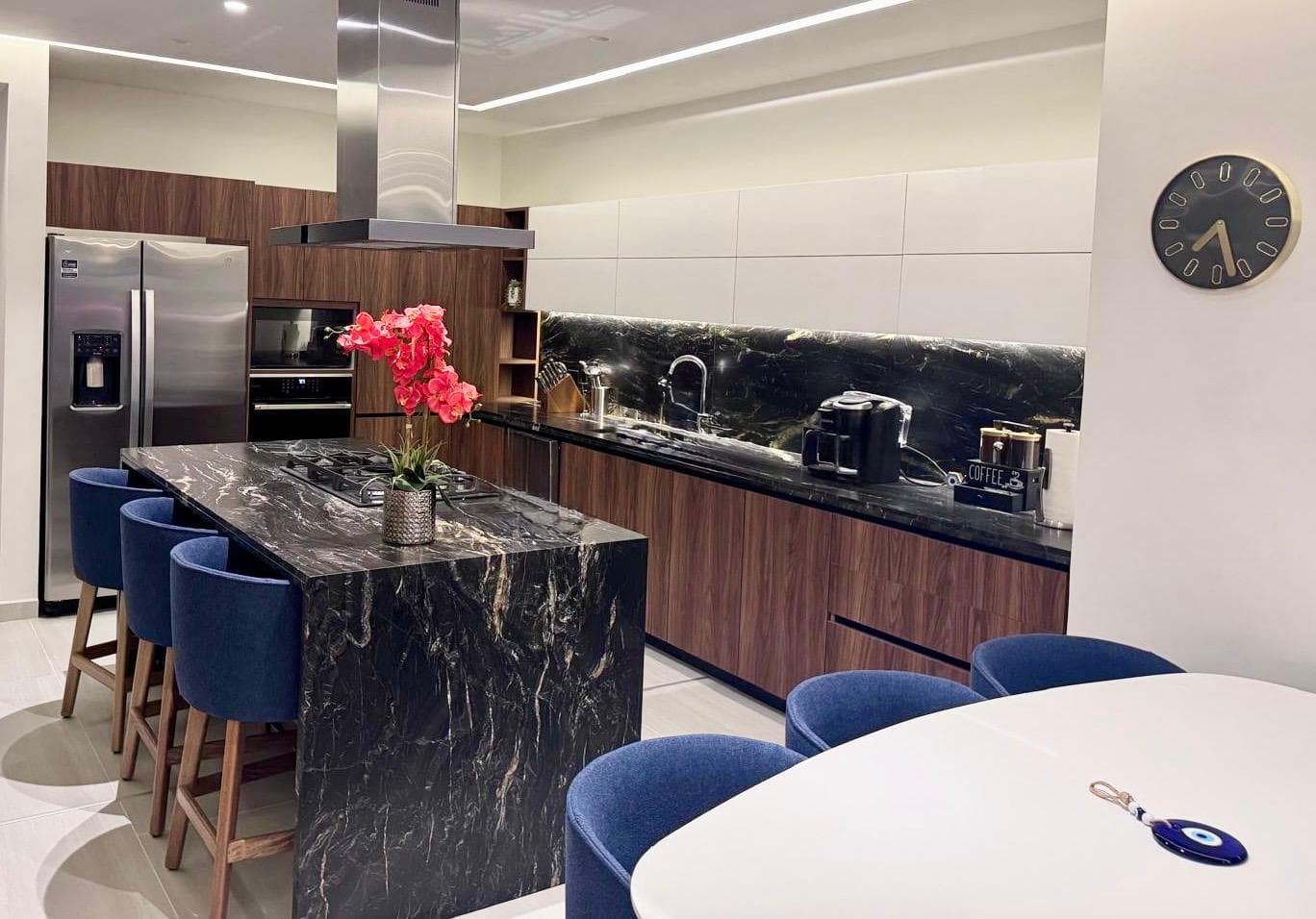 A fully loaded chef's kitchen — 6-burner gas stove, oven, fridge, microwave, island seating for 3, pots & pans, and a stocked spice rack. Everything you need, nothing you don't.